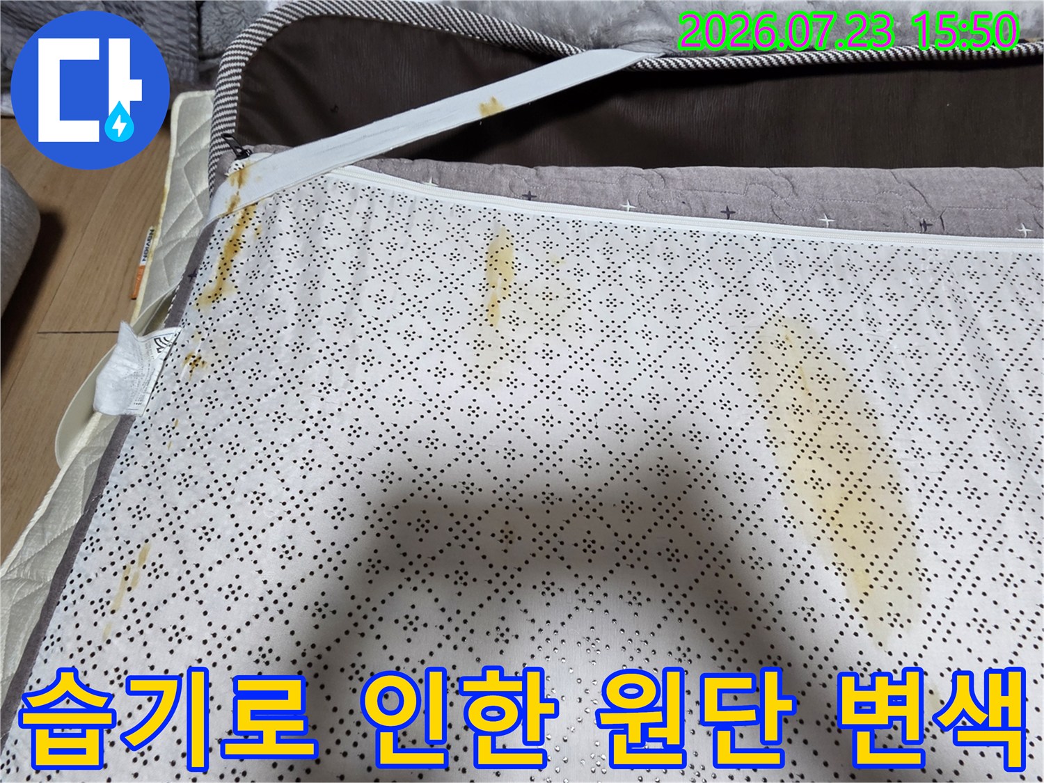 가구 하부 천에 나타난 불규칙한 모양의 노란색 물 얼룩-누수 증거