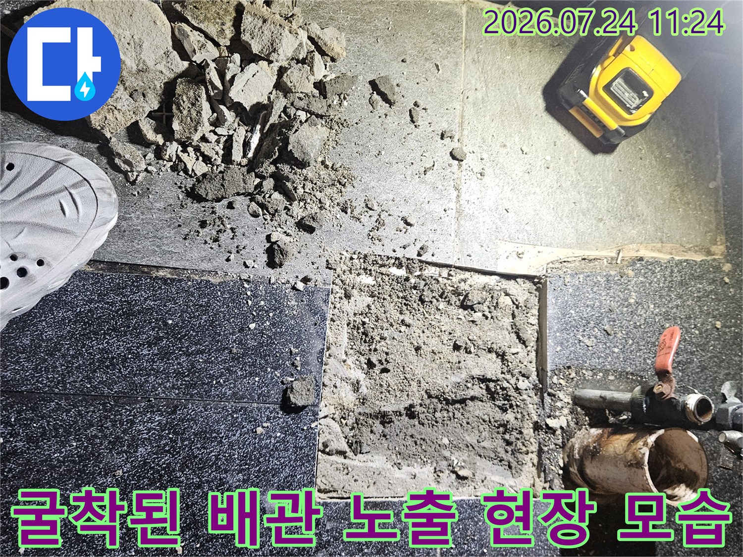 굴착 작업 후 드러난 온수 배관과 주변의 파쇄된 타일 조공들