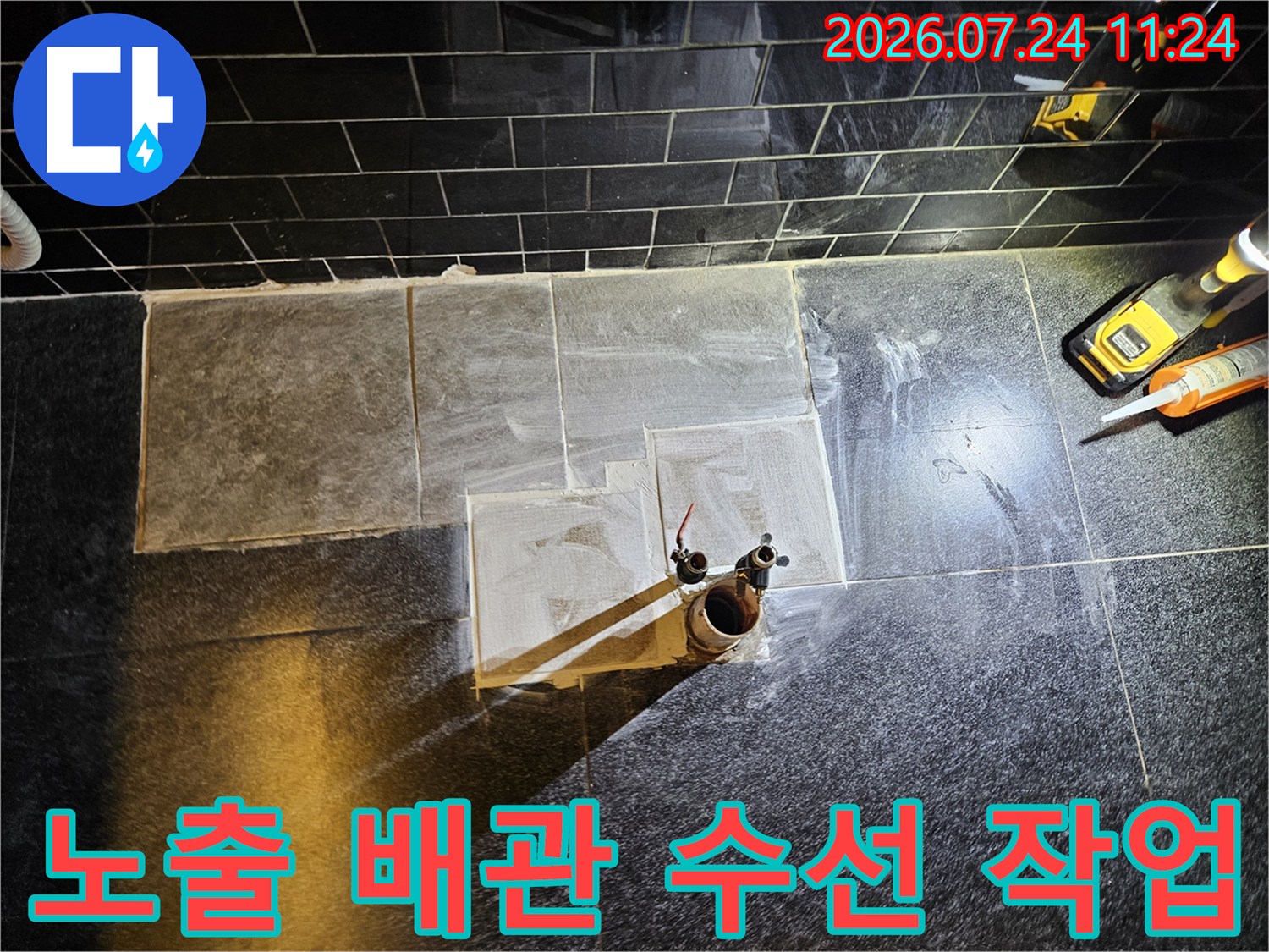 굴착된 벽면에서 노출된 온수 배관을 점검하는 누수 공사 장면