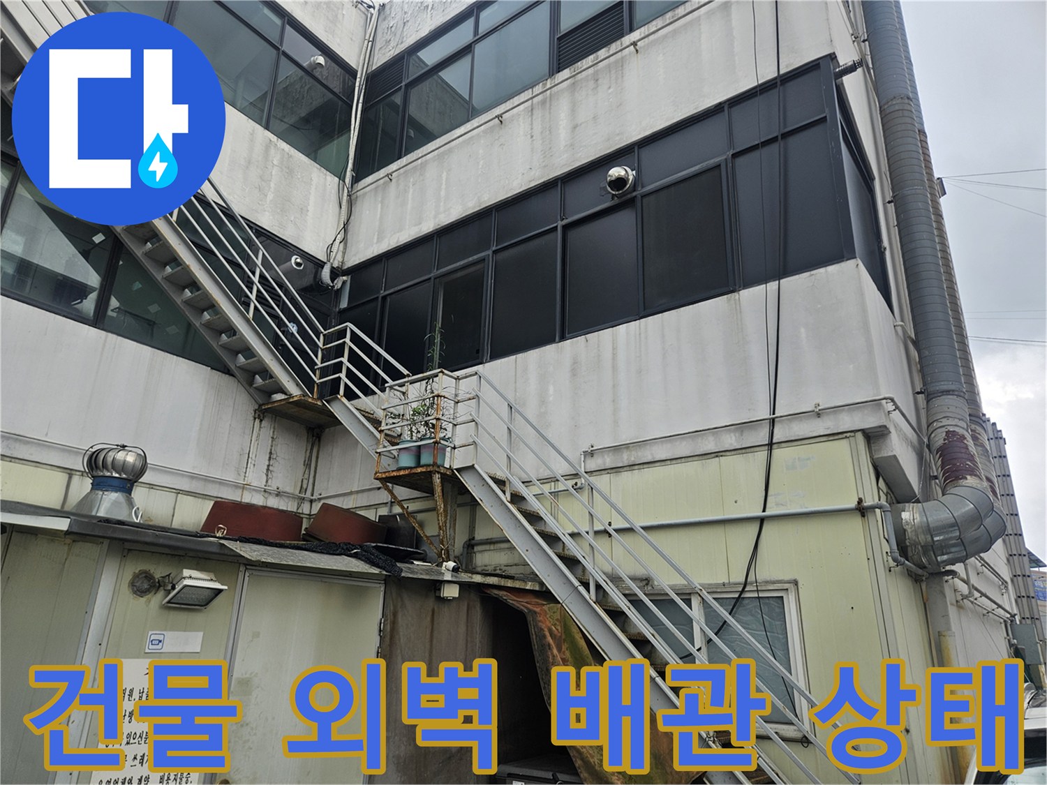 부천 역곡동 상가 건물 외벽에 설치된 외부 배관과 구조물 모습입니다.