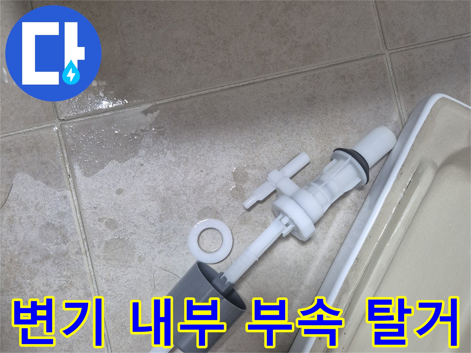 분리된 변기 필밸브와 밸브가 타일 위에 놓인 사진