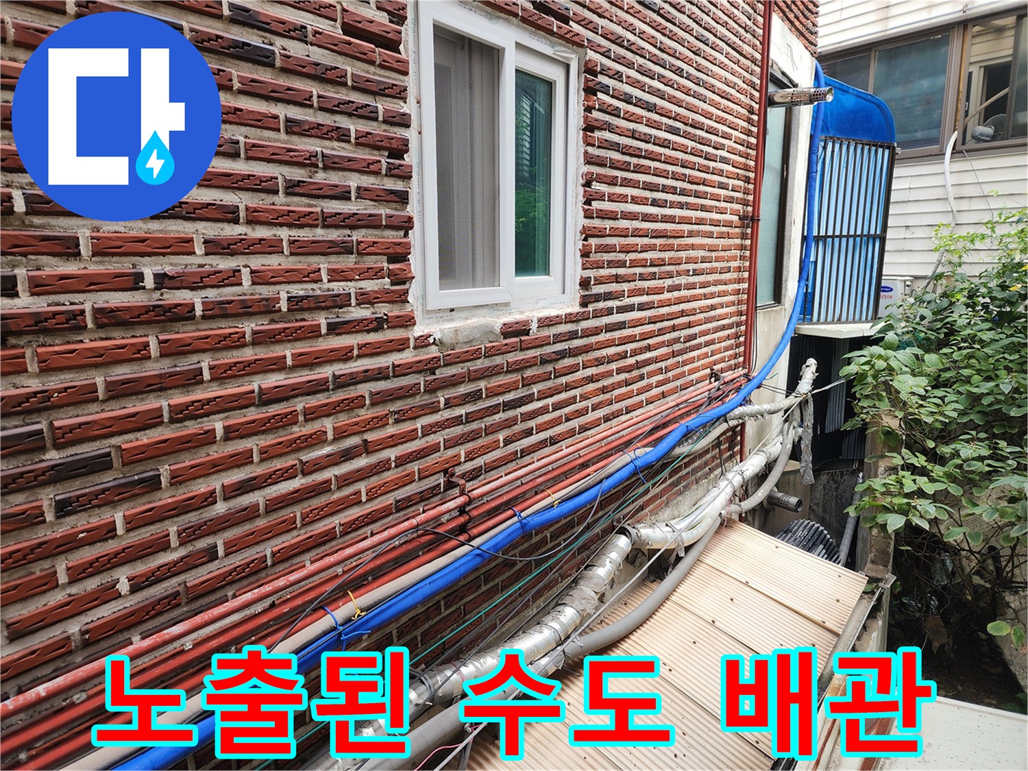 벽돌 건물 외부에 설치된 여러 가닥의 보온재 배관-동파 위험 구간 확인