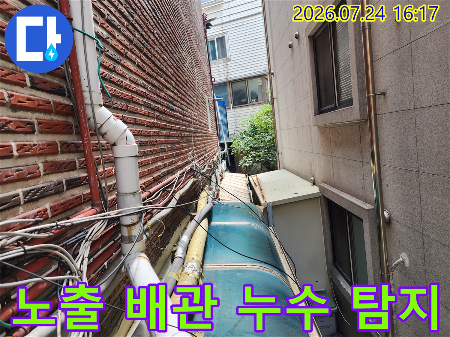 상가 건물 외벽에 설치된 복합적인 형태의 수도 및 가스 공급 시설