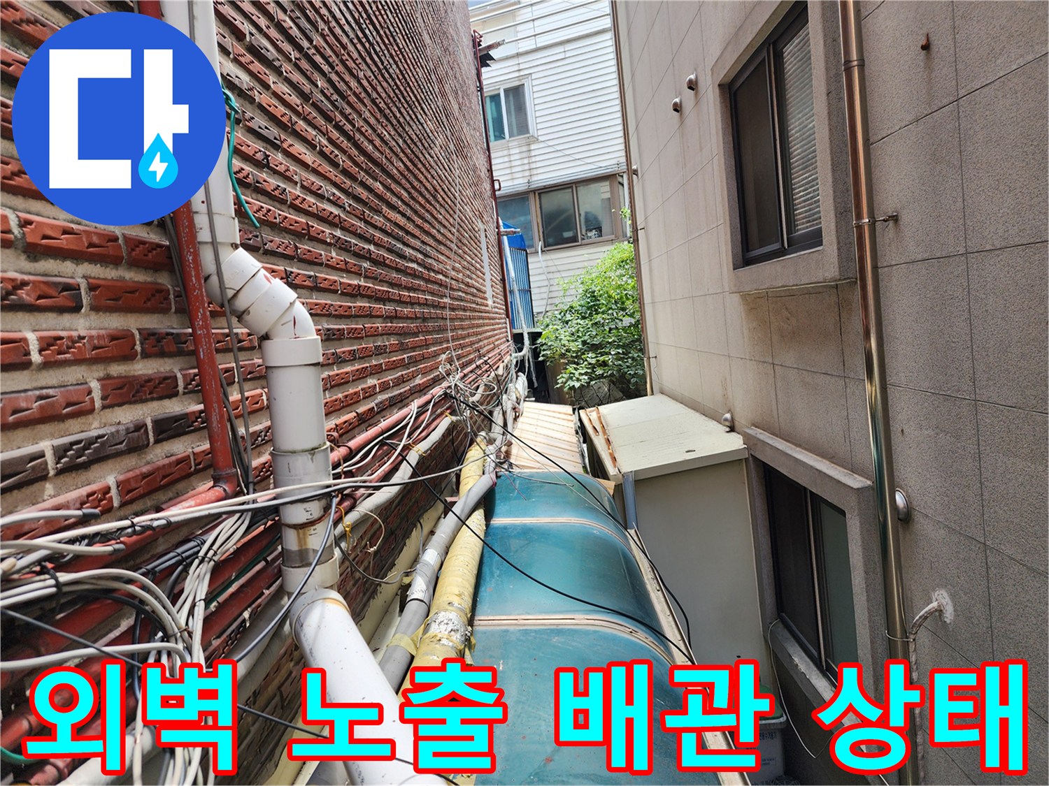 성북구 건물 외벽에 설치된 노출 배관과 낡은 보온재 상태를 보여주는 사진입니다.