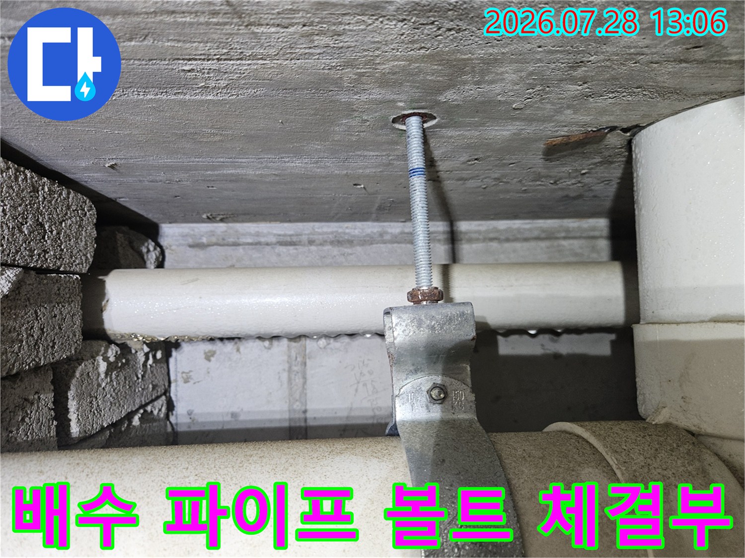 볼트로 고정된 흰색 배수관 부위의 상세 사진