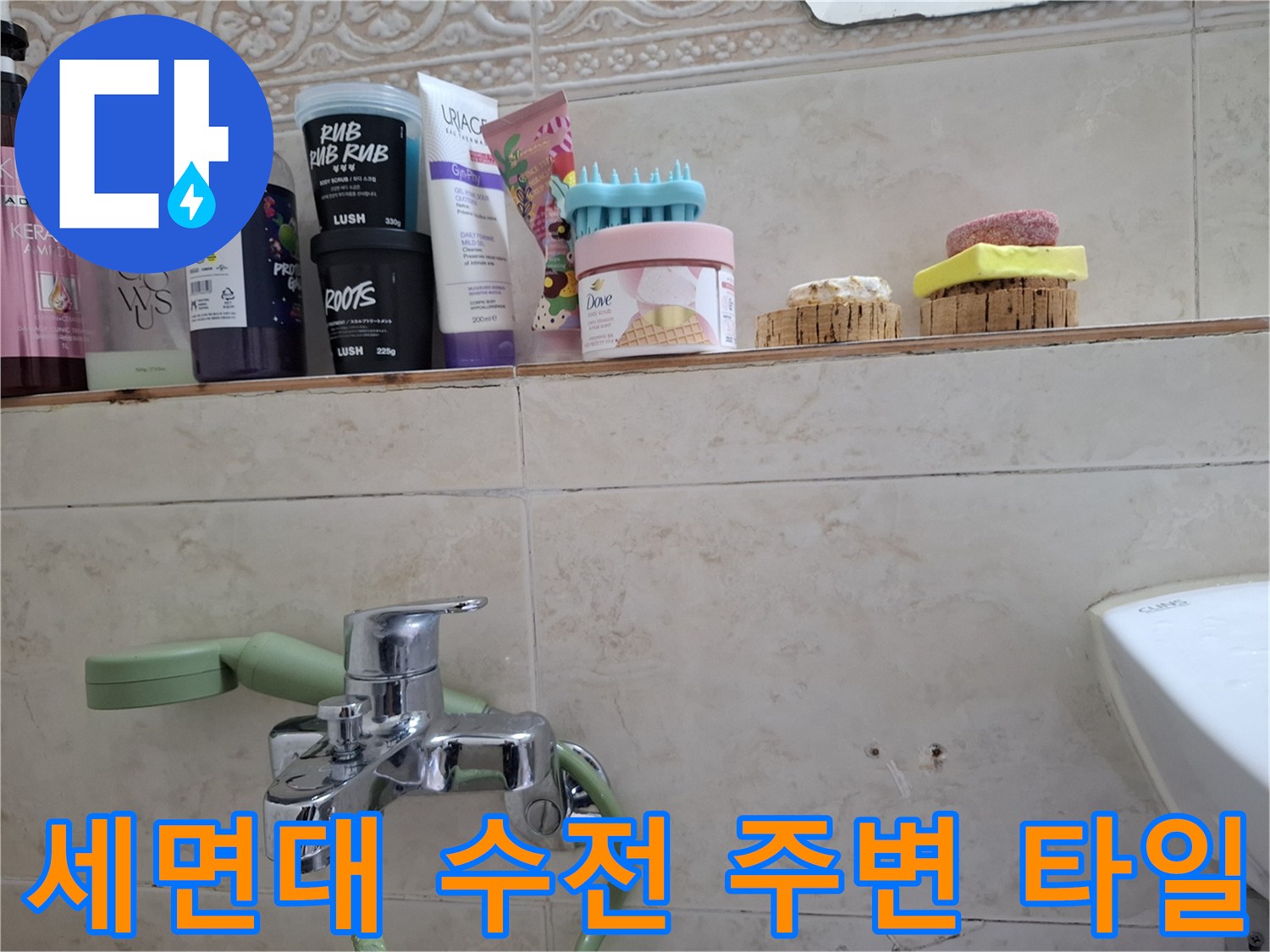 욕실 선반 아래 세면대 수전과 벽면 타일 사이의 상태를 보여주는 사진