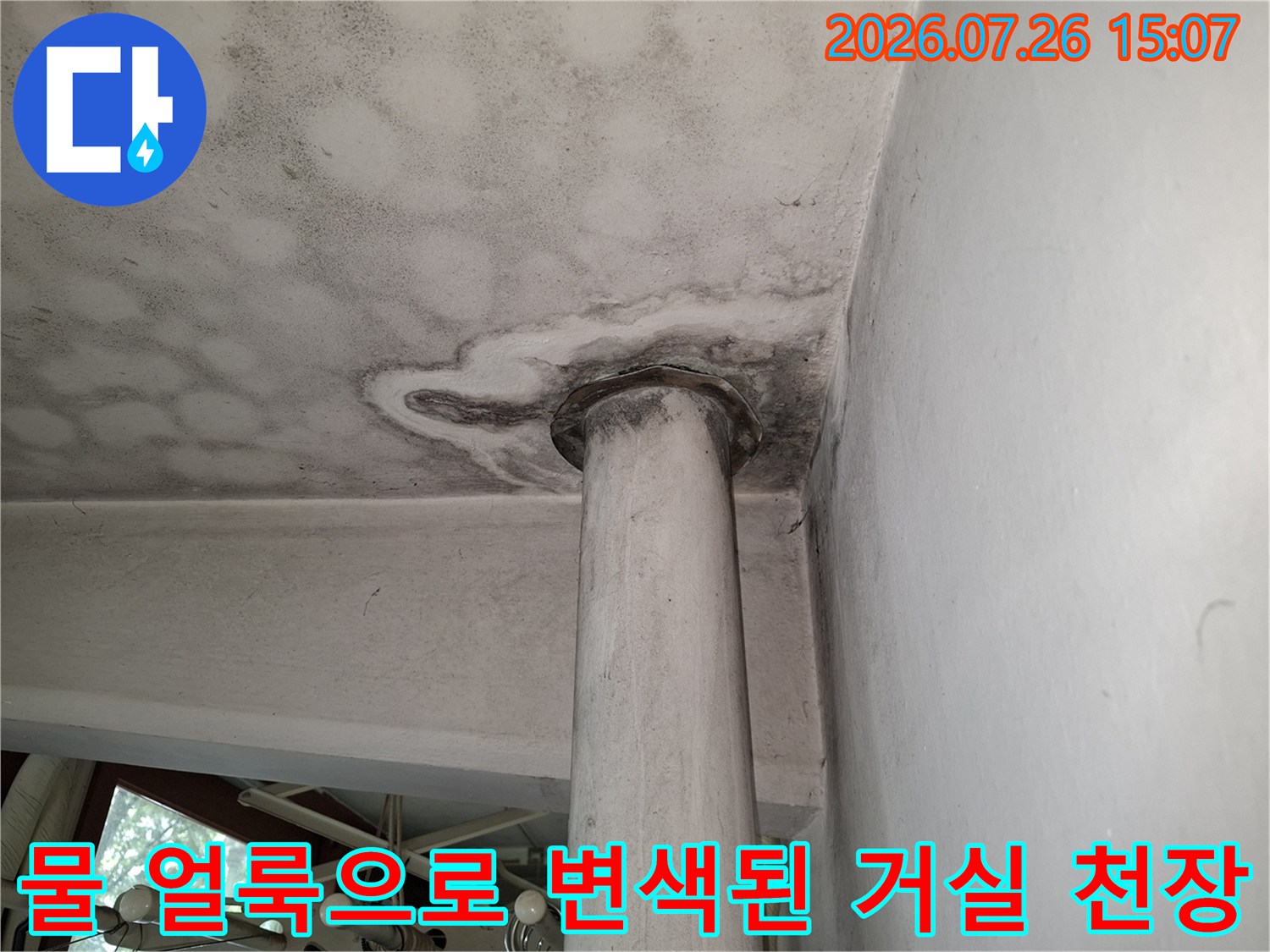 흰색의 매끄러운 천장과 기둥 연결 부위에 발생한 어두운 톤의 누수 오염 자국