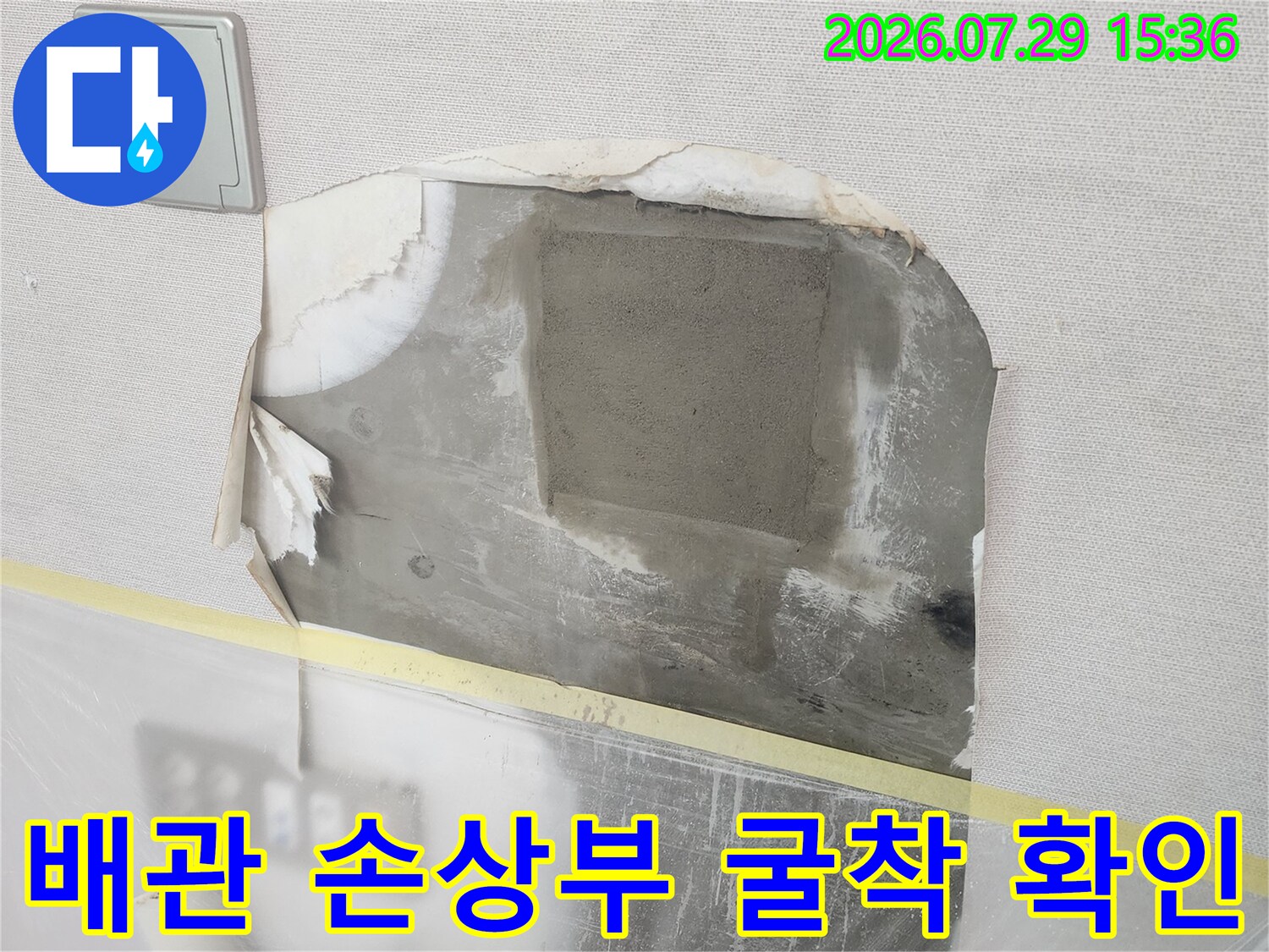 벽면을 파낸 후 나타난 배관의 노출 상태를 촬영한 수리 공정 사진