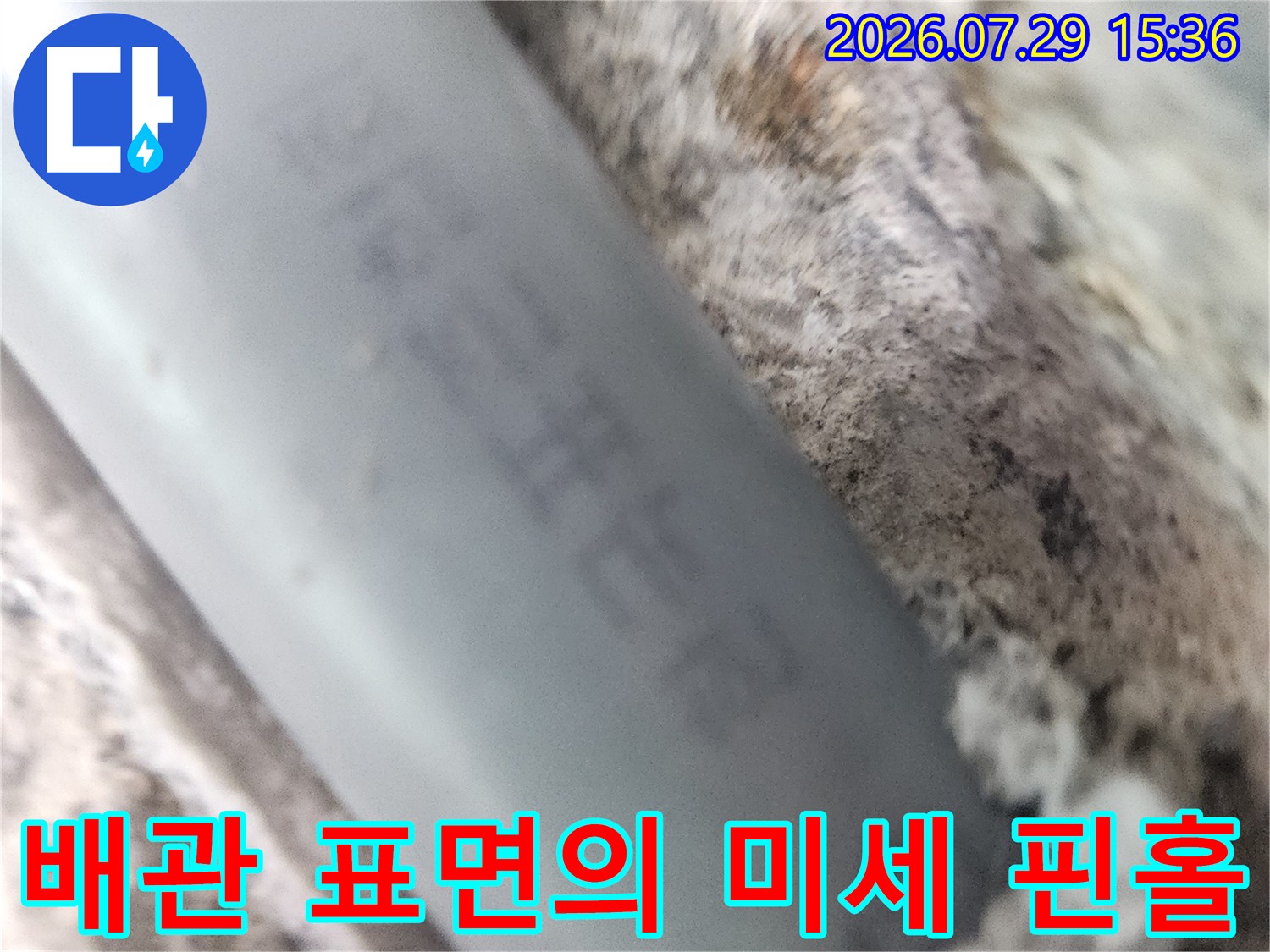 회색 배관 위에 발생한 작은 구멍과 주변 파손 부위