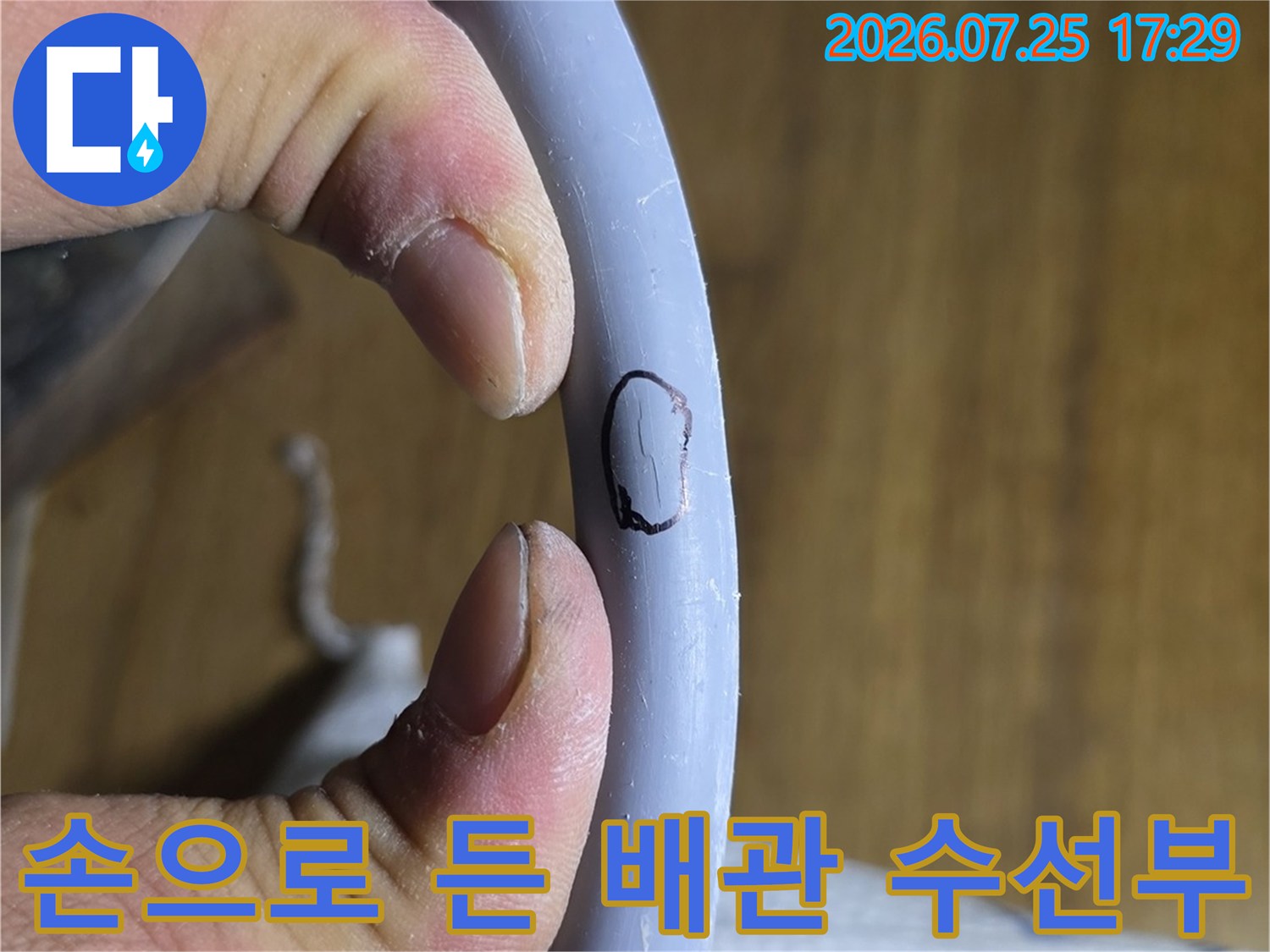 장갑을 끼고 손으로 파손된 에이콘 배관 부위를 고정하여 보여주는 장면