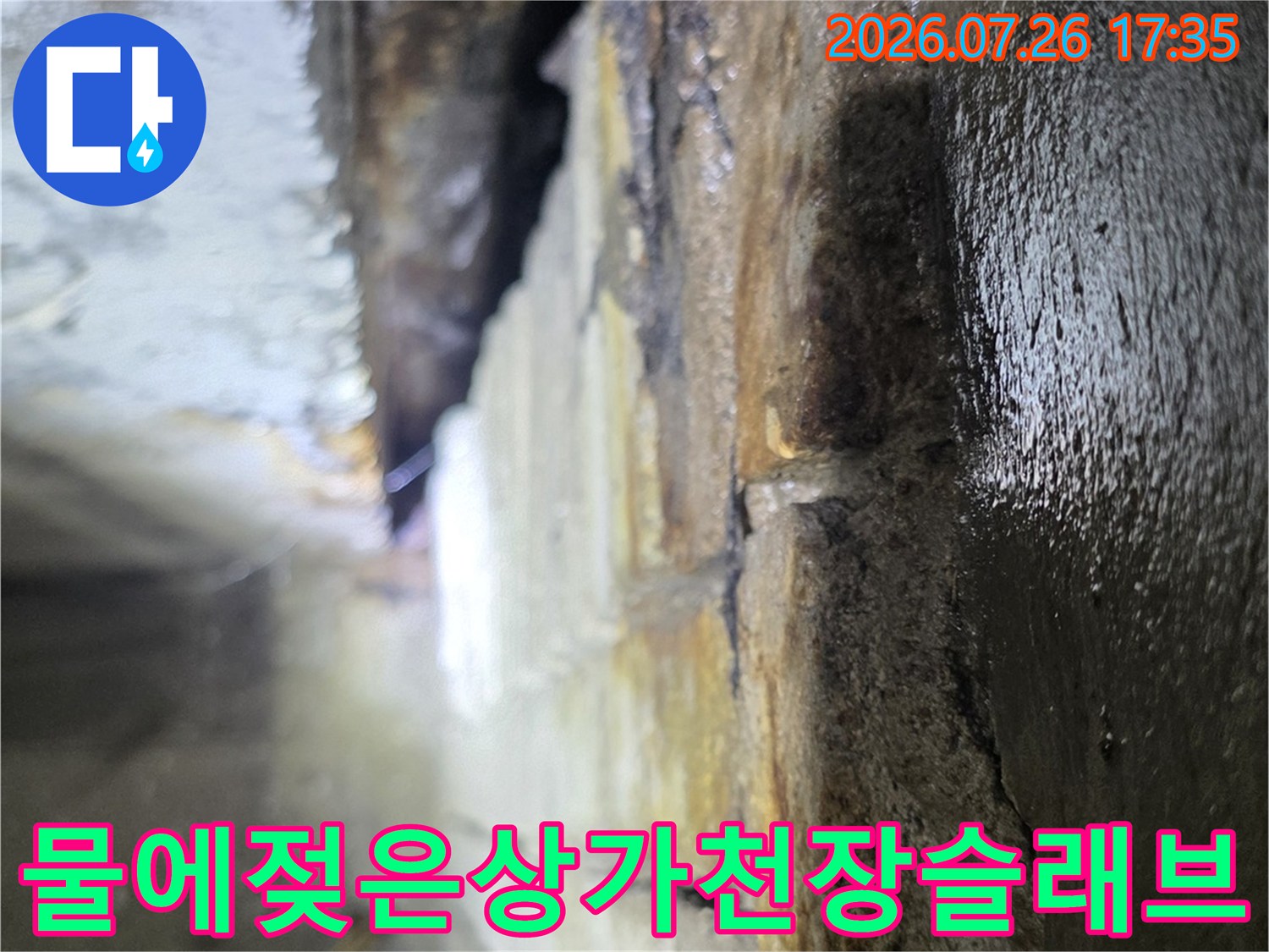 상가 건물 내부의 물에 젖어 변색된 천장 슬래브와 배관 주변 모습