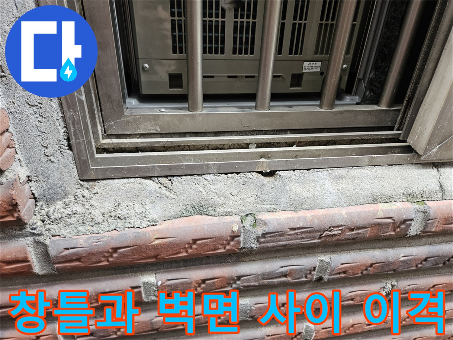 알루미늄 창틀 하단과 노후된 벽돌 구조물 사이의 틈을 보여줍니다.
