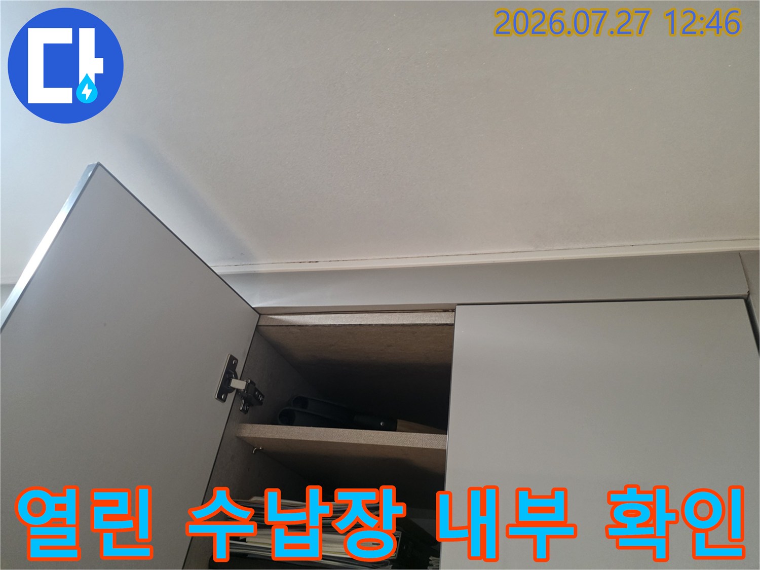 흰색 가구의 문이 열려 있고 내부에 서류와 선반이 보이는 근접 촬영 사진