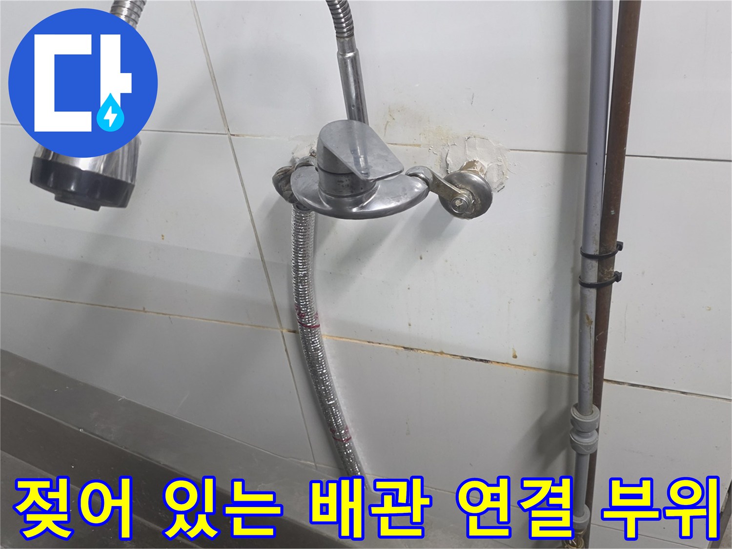 배관 연결 틈새에서 흘러나온 물로 인해 젖은 벽면 타일
