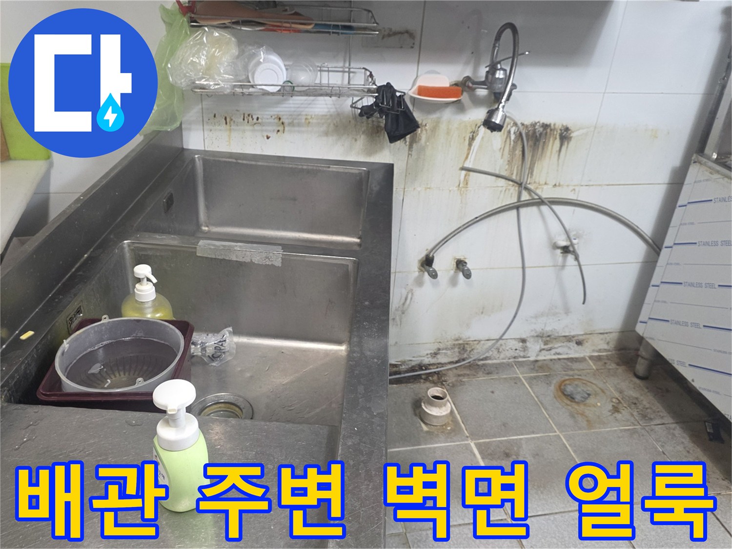 상업용 주방 싱크대 뒤쪽의 누수 흔적과 오염된 벽면