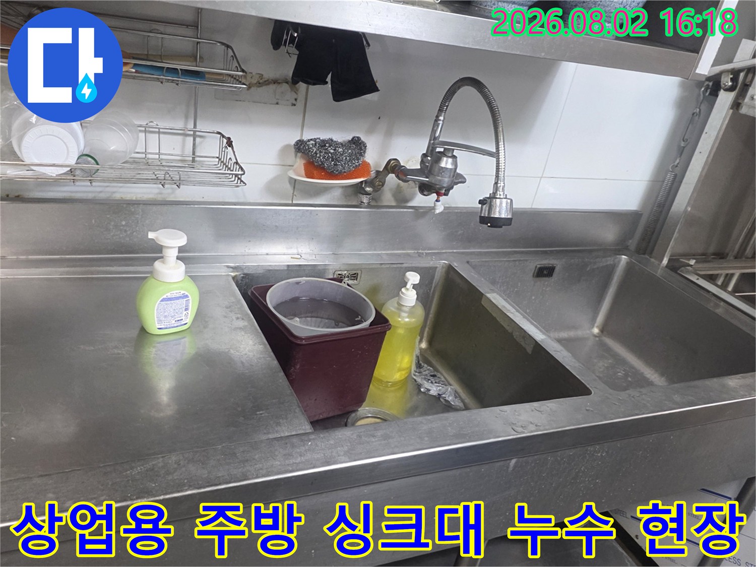 상업용 주방의 스테인리스 싱크대와 배관 주변 점검 모습