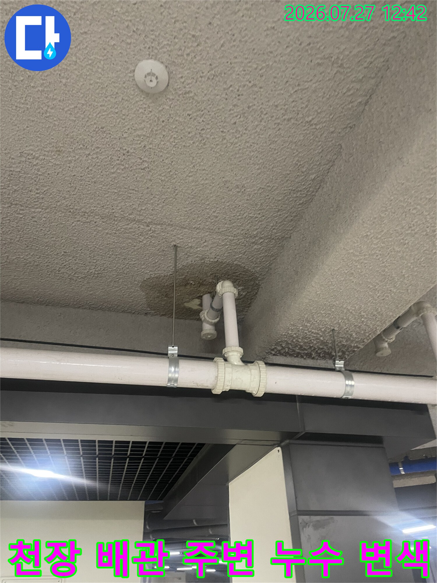 천장 마감재에 물자국이 남은 상태에서 흰색 PVC 배관이 설치된 현장 사진