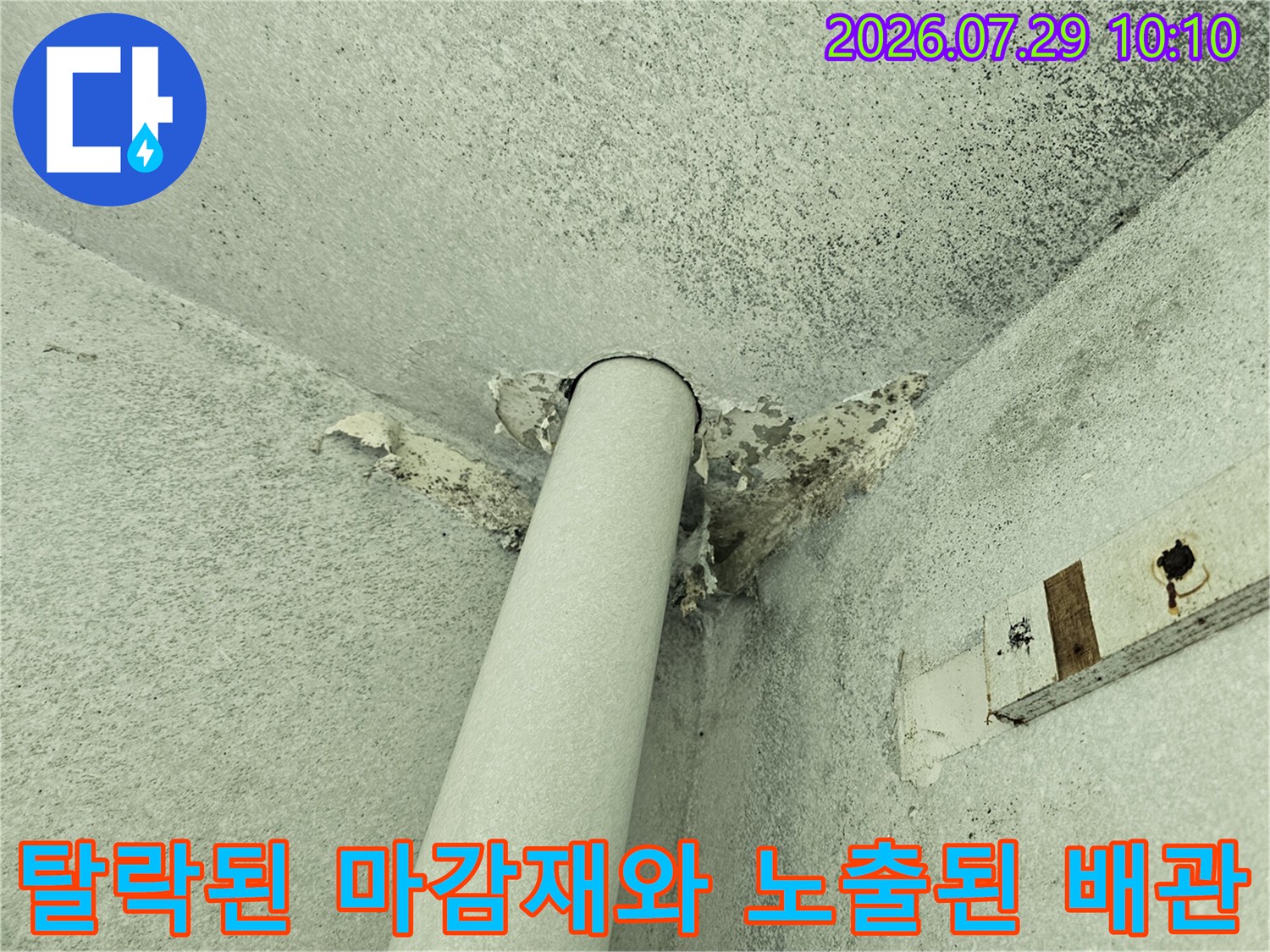 배관 주변의 파손된 마감면과 노출된 구조물