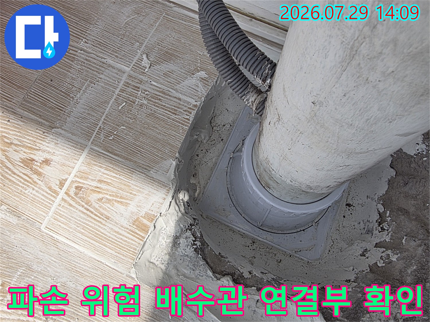 노출된 하얀색 PVC 배수관과 주변 시멘트가 벗겨진 구간의 모습