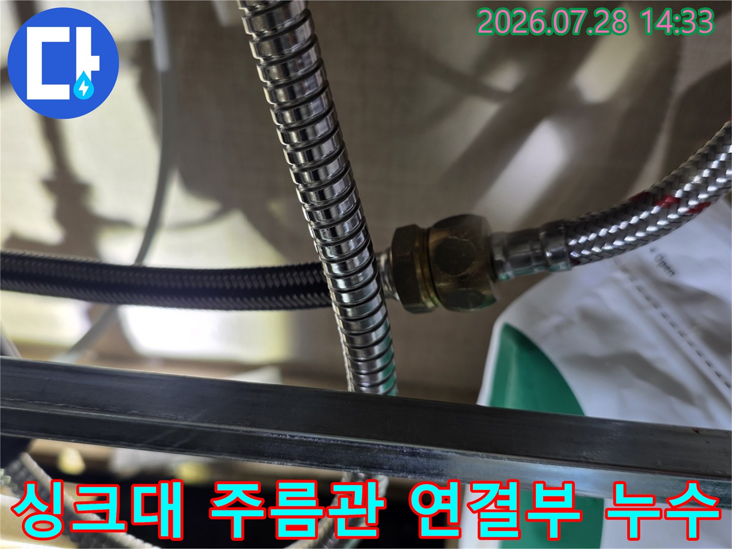 싱크대 하부의 스테인리스 주름관 연결 너트 부위에서 물기가 비치는 모습