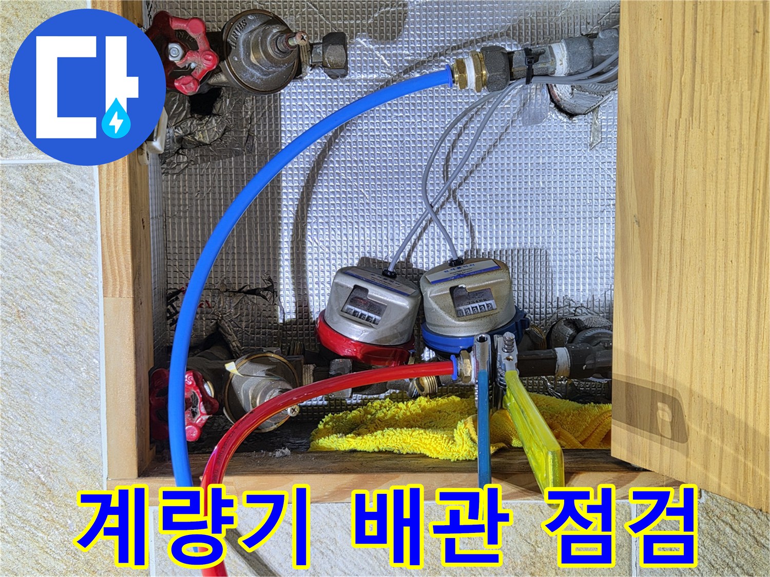 수도 계량기와 연결된 파란색 및 빨간색 배관의 상태를 확인하는 모습