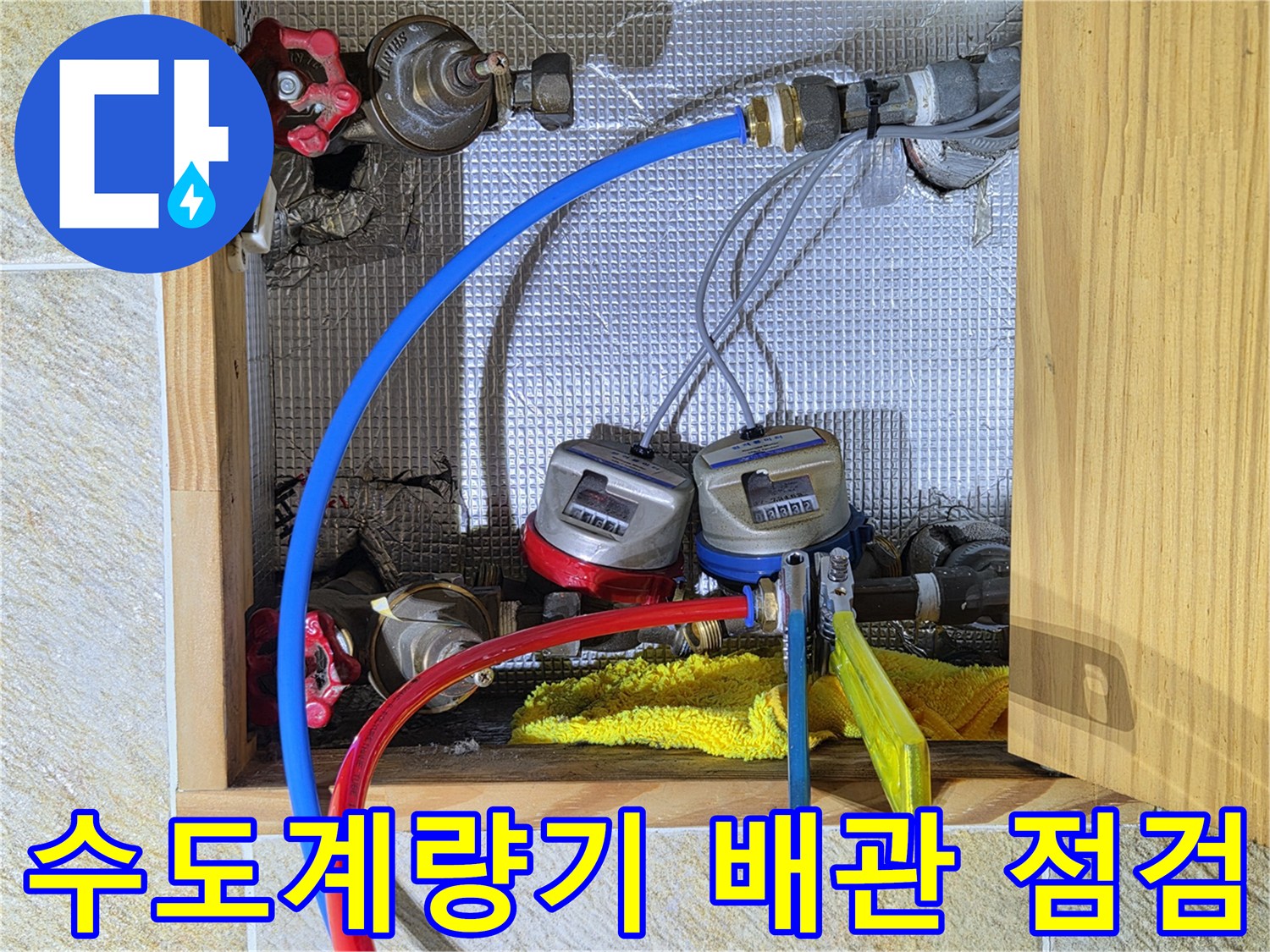 수도계량기와 연결된 파란색 및 빨간색 배관의 상태를 확인하는 모습