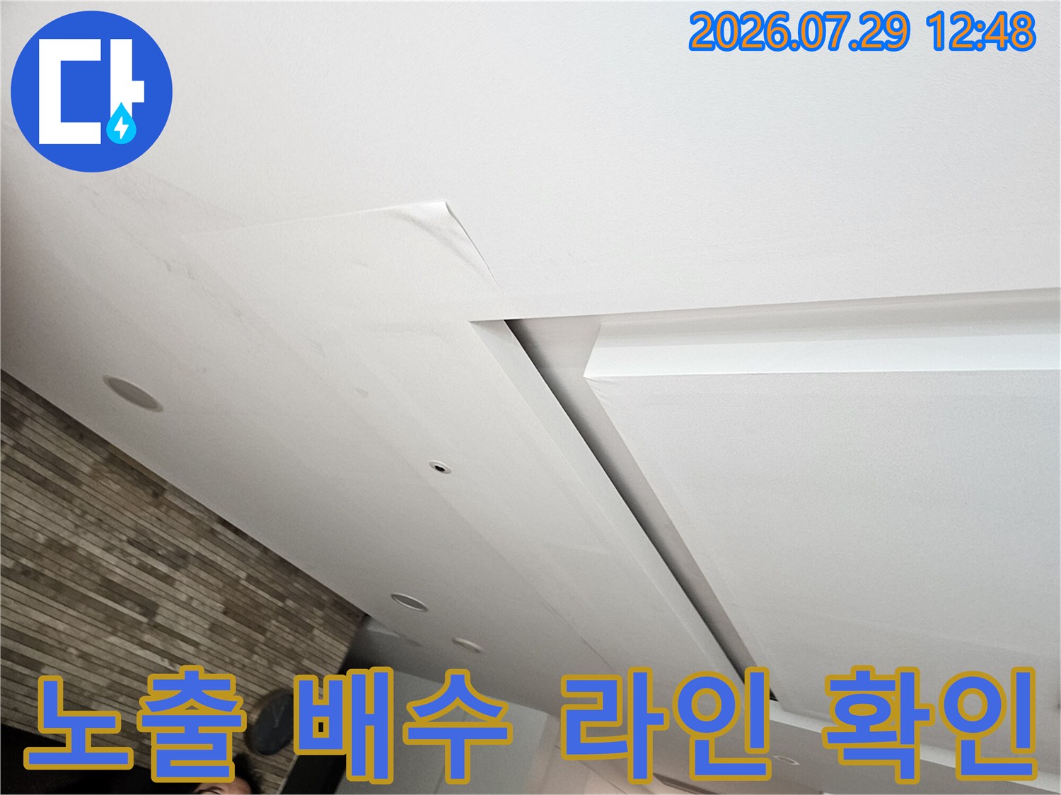 거실 천장 내부 마감재를 뜯어낸 후 노출된 배관을 카메라로 정밀하게 점검하는 장면