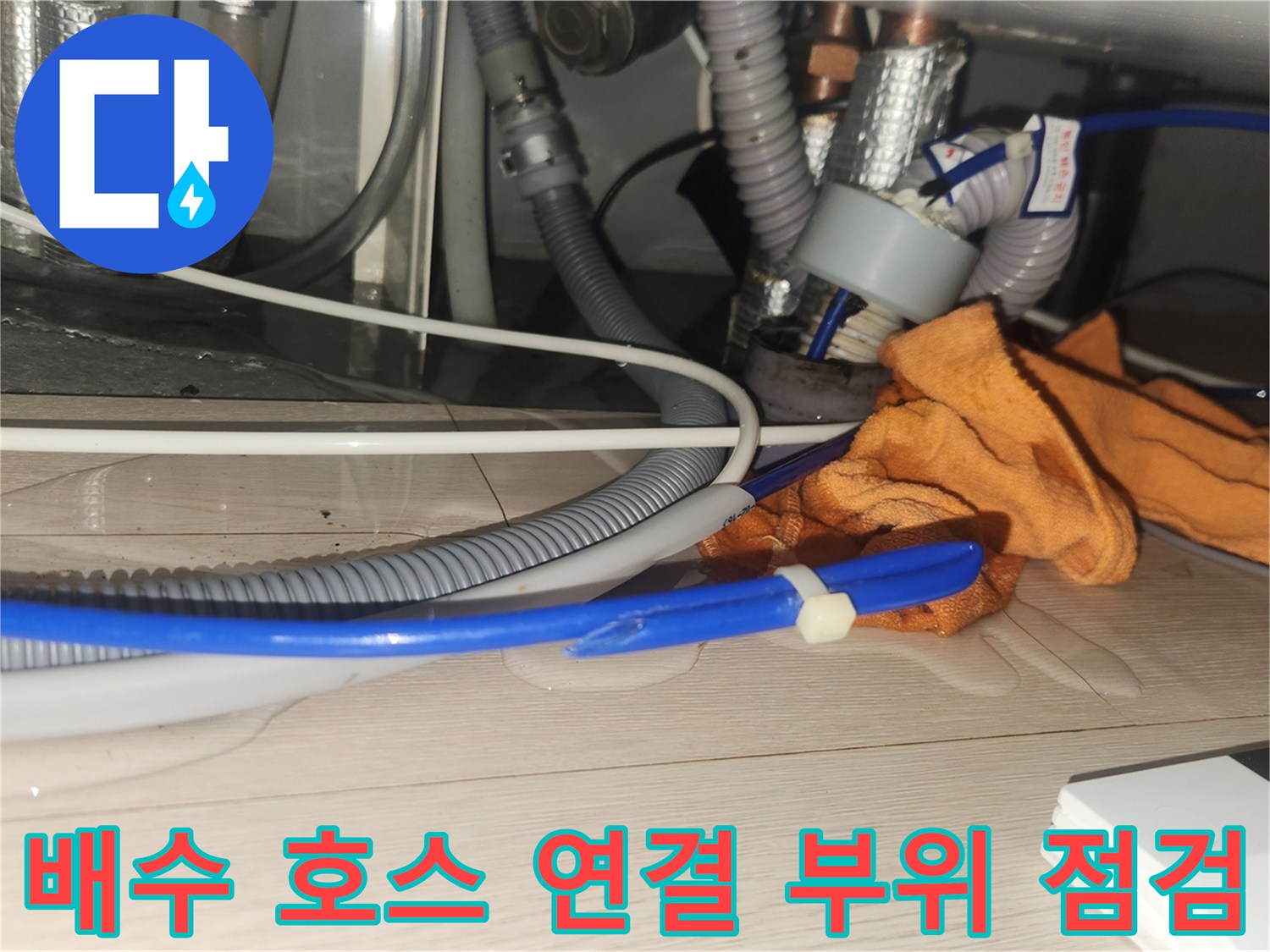 싱크대 아래쪽-누수가 의심되는 파란색 호스와 은색 배관 연결부