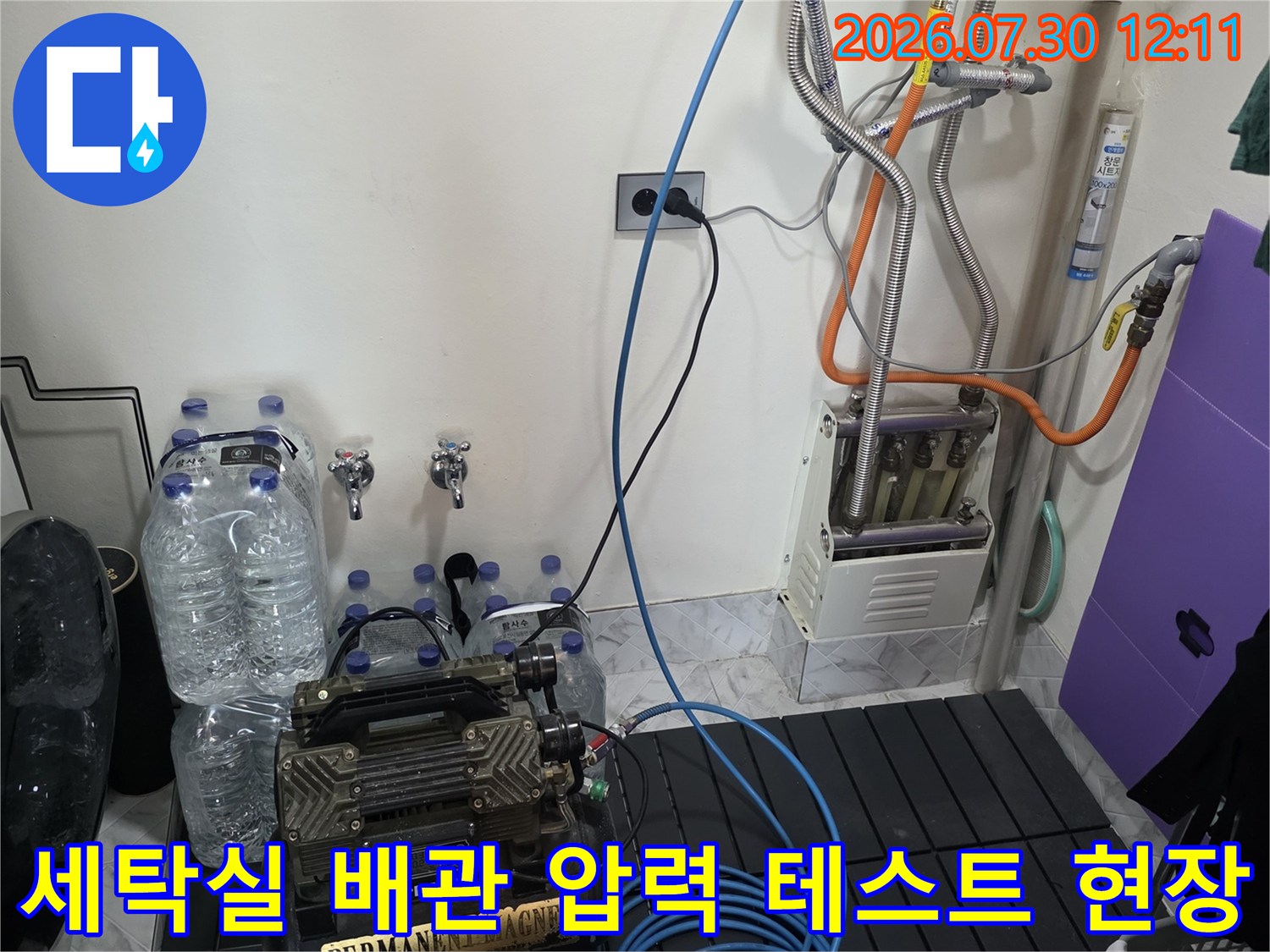 복잡한 세탁기 주변 배관에 공압 장치를 연결해 누수 여부를 정밀 진단하는 모습