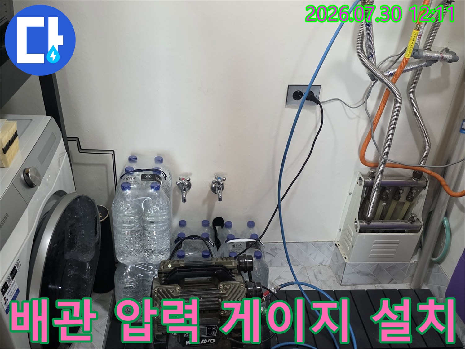 세탁실 내 노출된 배관에 공기압 측정 장치를 연결하여 누수 여부를 세밀하게 확인하는 모습