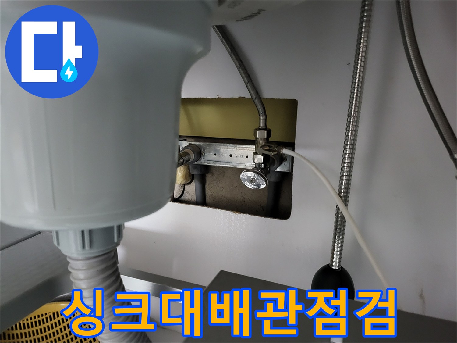 싱크대 아래쪽 수도 연결 부위와 압력 측정 장치