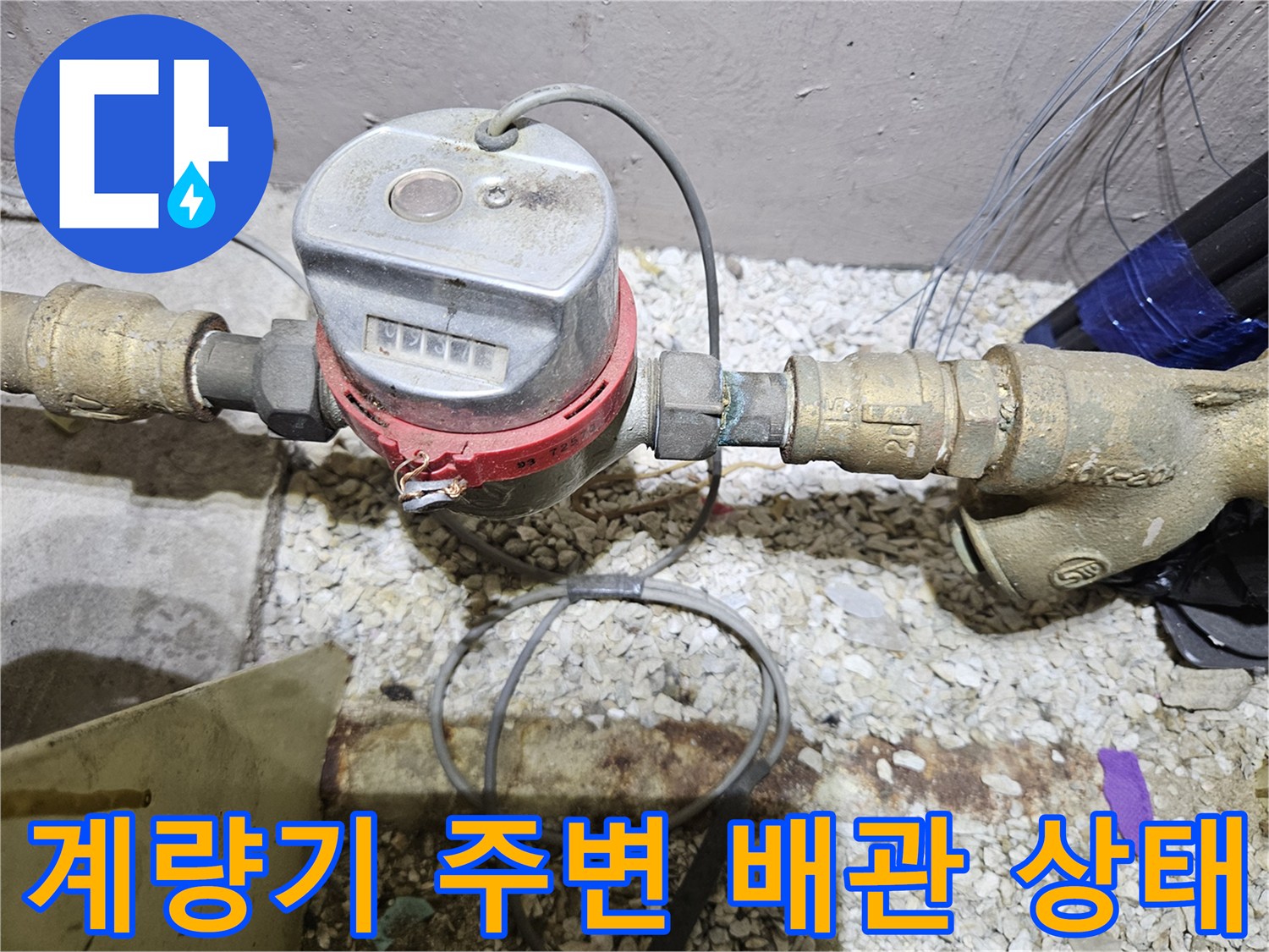 수도 계량기와 연결된 금속 부품 및 배관의 근접 촬영 이미지입니다.