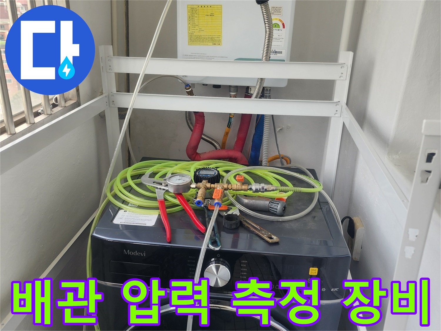 보일러 하단 배관에 연결된 다양한 색상의 호스와 게이지