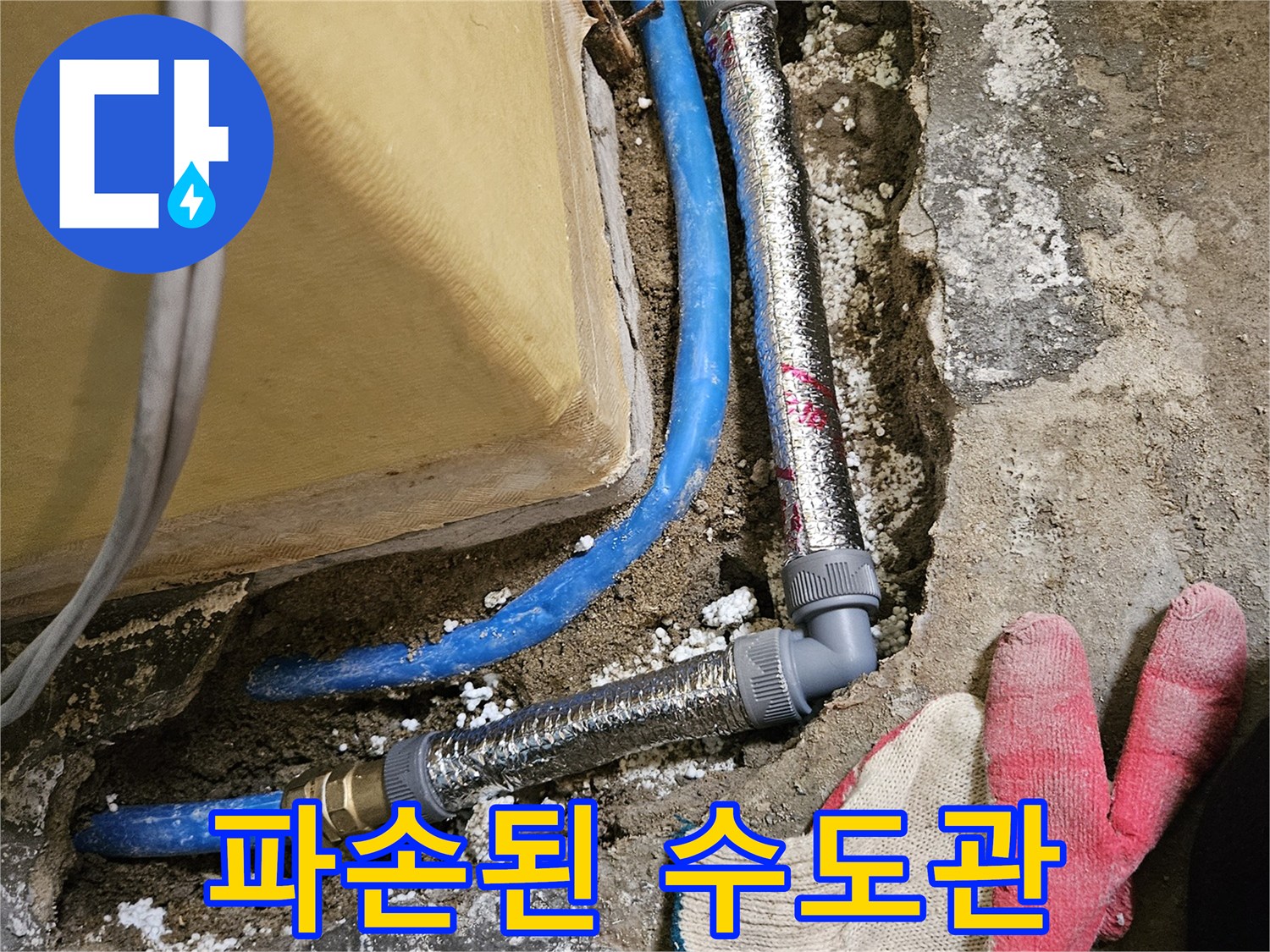 굴착된 바닥 내부-파란색 배관과 은색 보온재가 씌워진 연결 부속의 모습