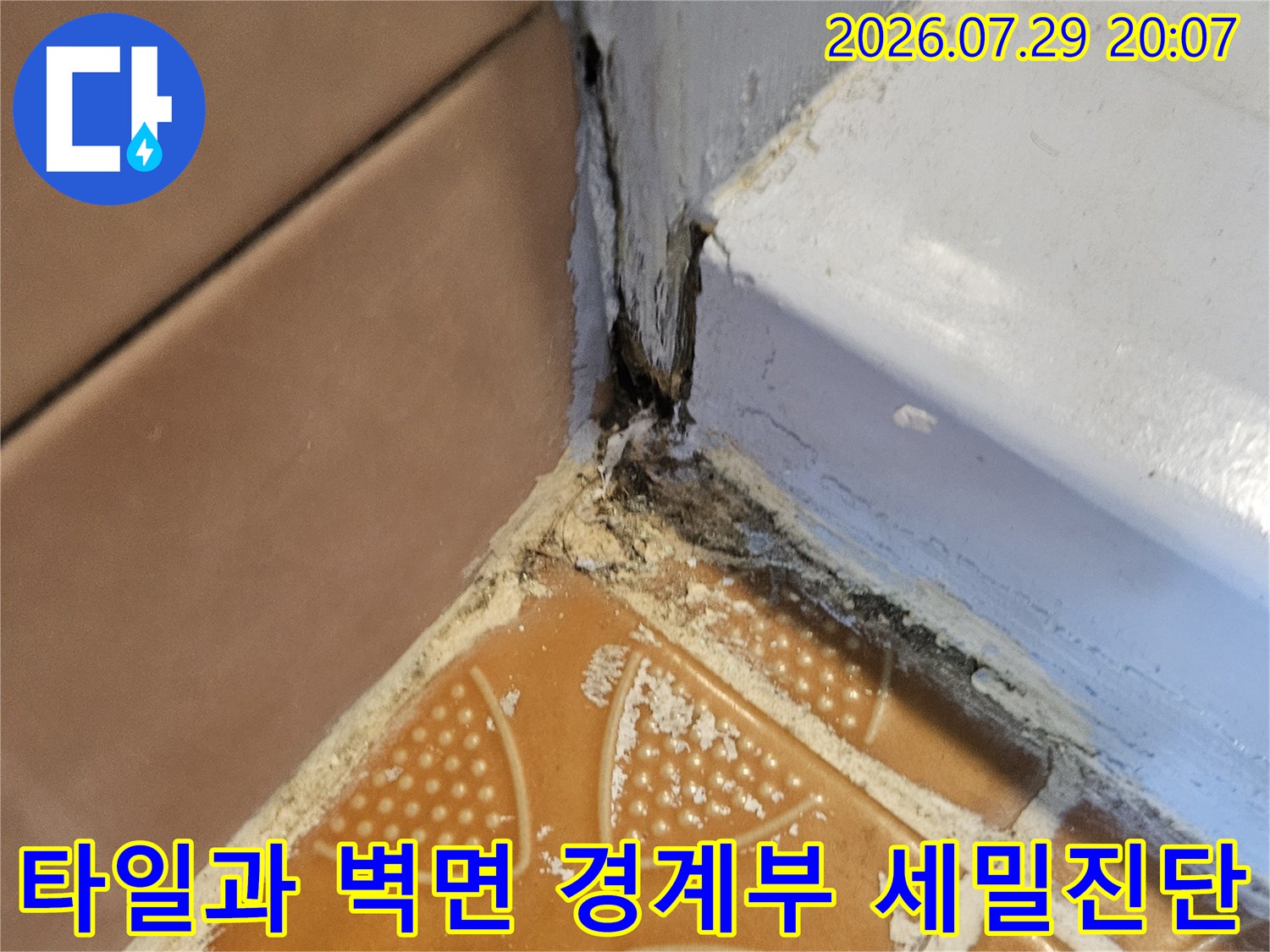 벽체와 타일이 만나는 틈새를 통해 누수가 발생하고 있는 현장을 촬영한 사진