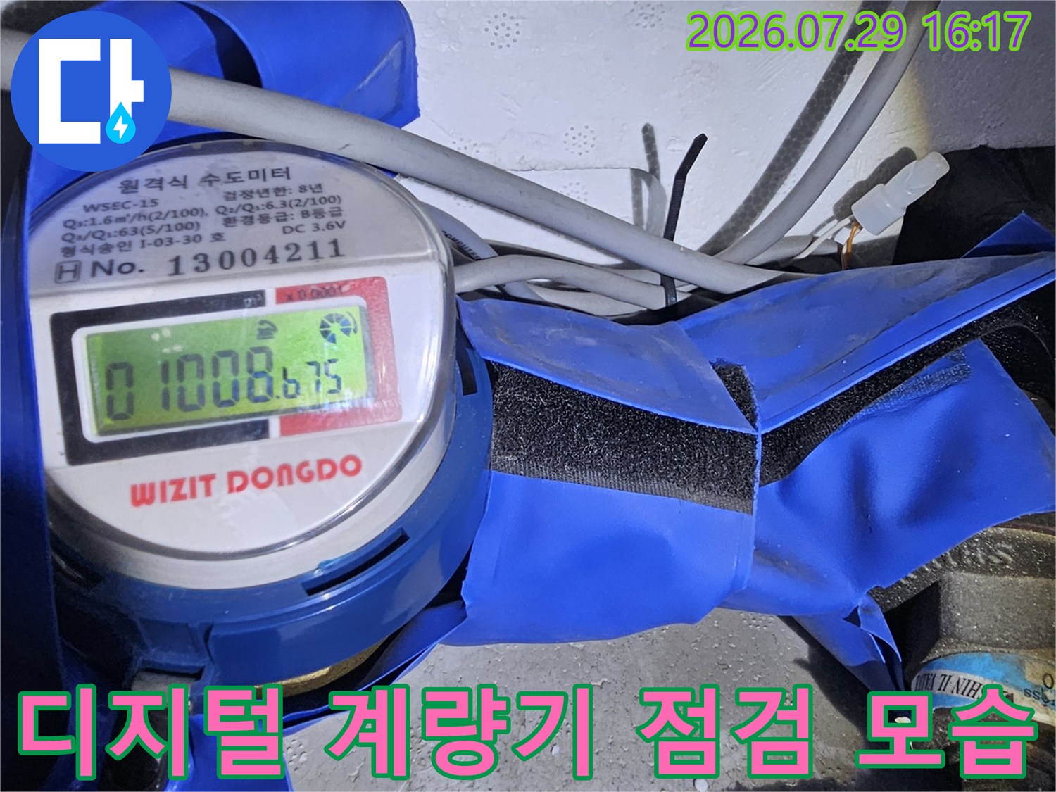 디지털 숫자 표시가 있는 수압계와 파란색 보온재로 감싸진 수도 배관