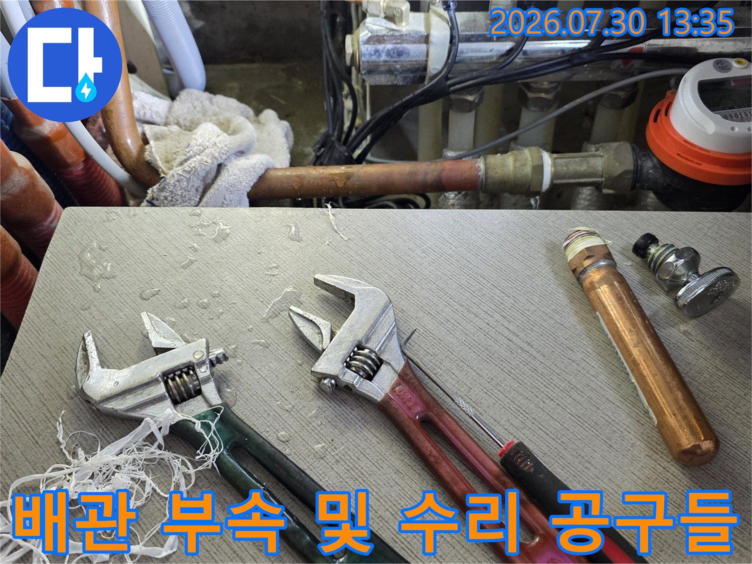몽키스패너와 구리 배관용 피팅이 놓인 작업 공간