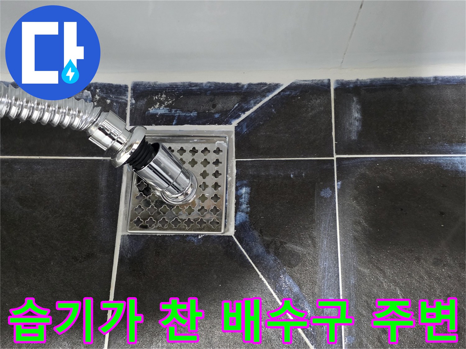 배수구 덮개와 타일 사이의 물기를 근접 촬영한 사진입니다.