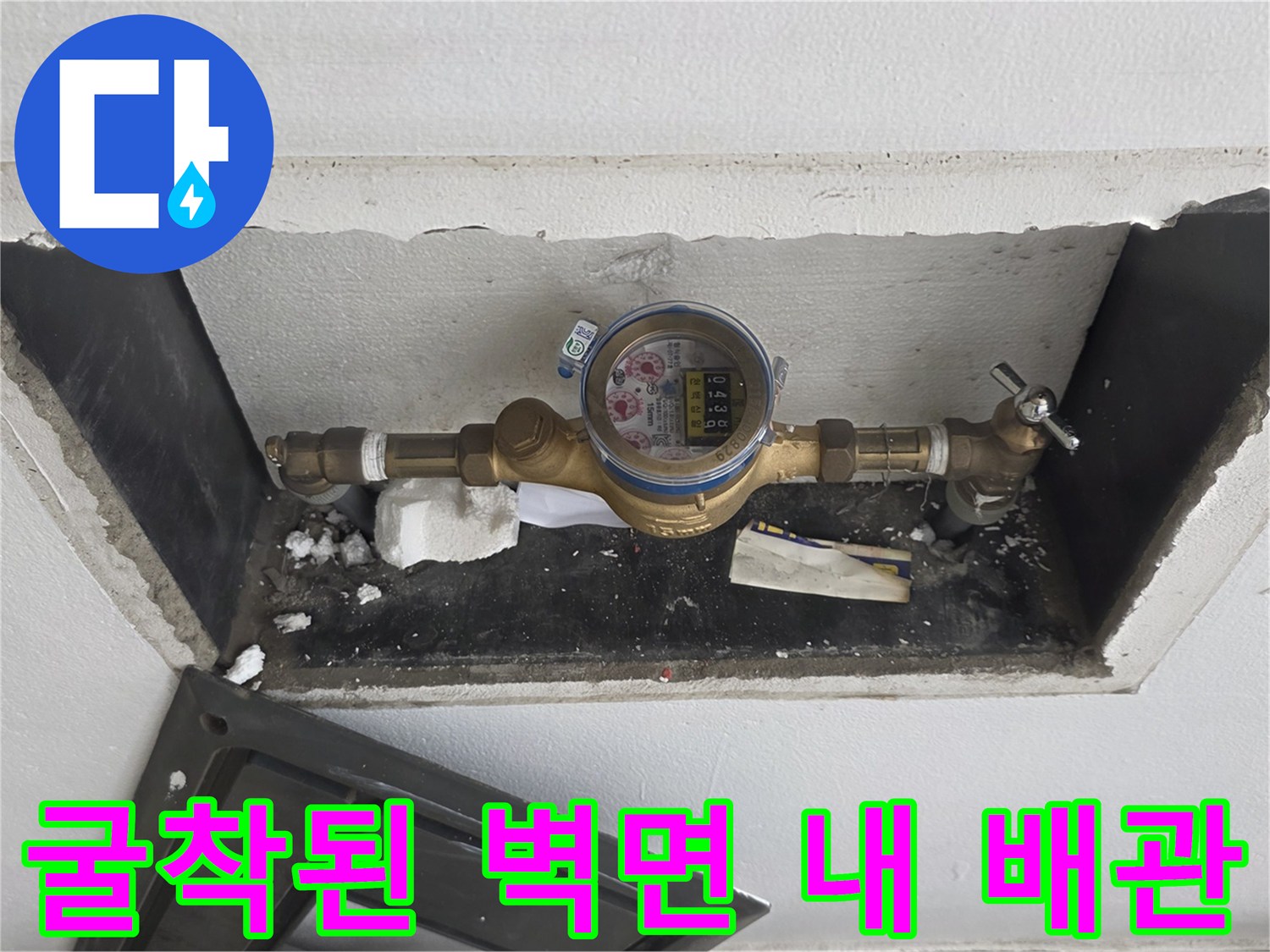 벽을 뚫어 노출시킨 수도 계량기와 금속 부속품