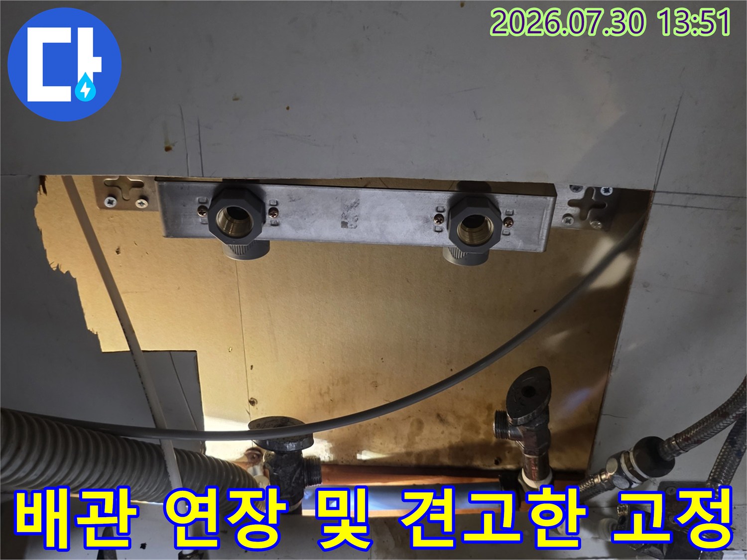 싱크대 아래쪽 하부 공간에서 배관을 재구성하고 브래킷으로 고정하는 모습