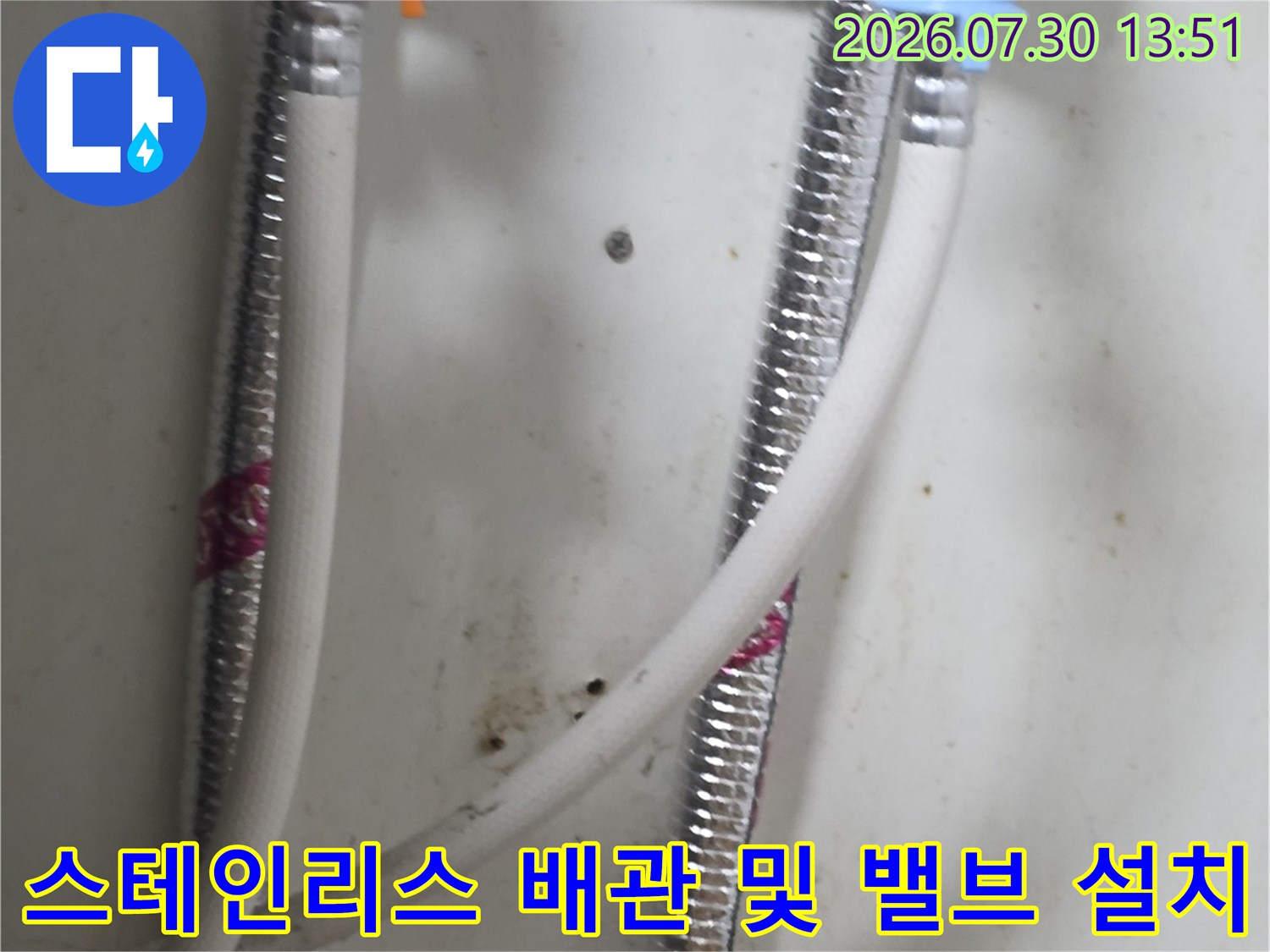 정비된 싱크대 아래 급수 시스템과 스테인리스 주름관