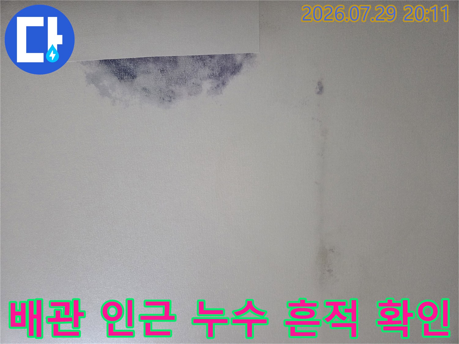 천장 안쪽 배관 노출 부위와 주변의 젖은 콘크리트면 비교