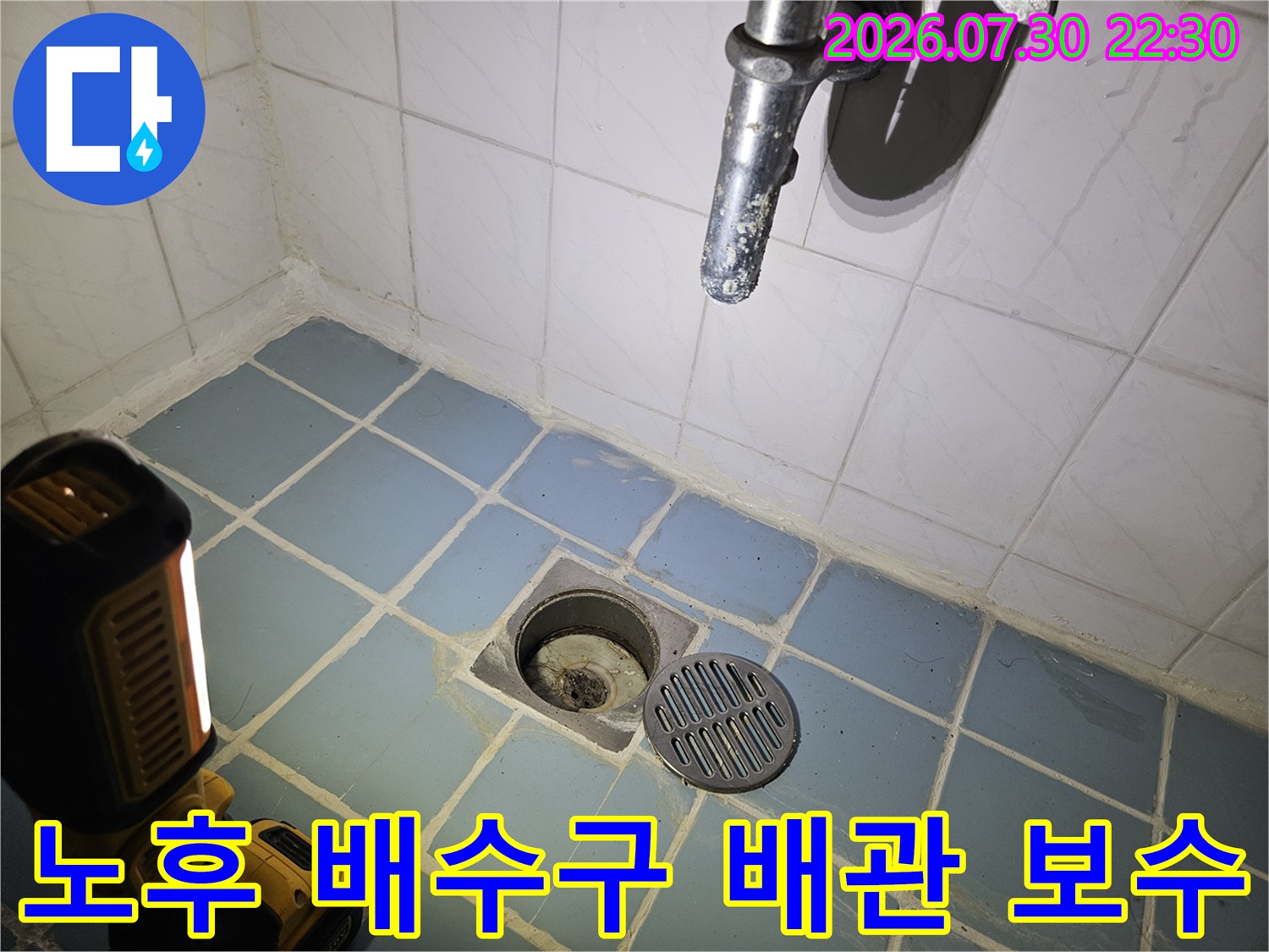 파란색 타일 아래 배치된 배수용 배관과 주변부의 오염 상태를 촬영한 사진