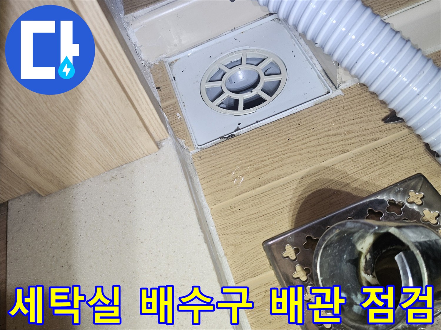 세탁실 바닥 유가와 연결된 백색 플라스틱 배관의 상세 모습