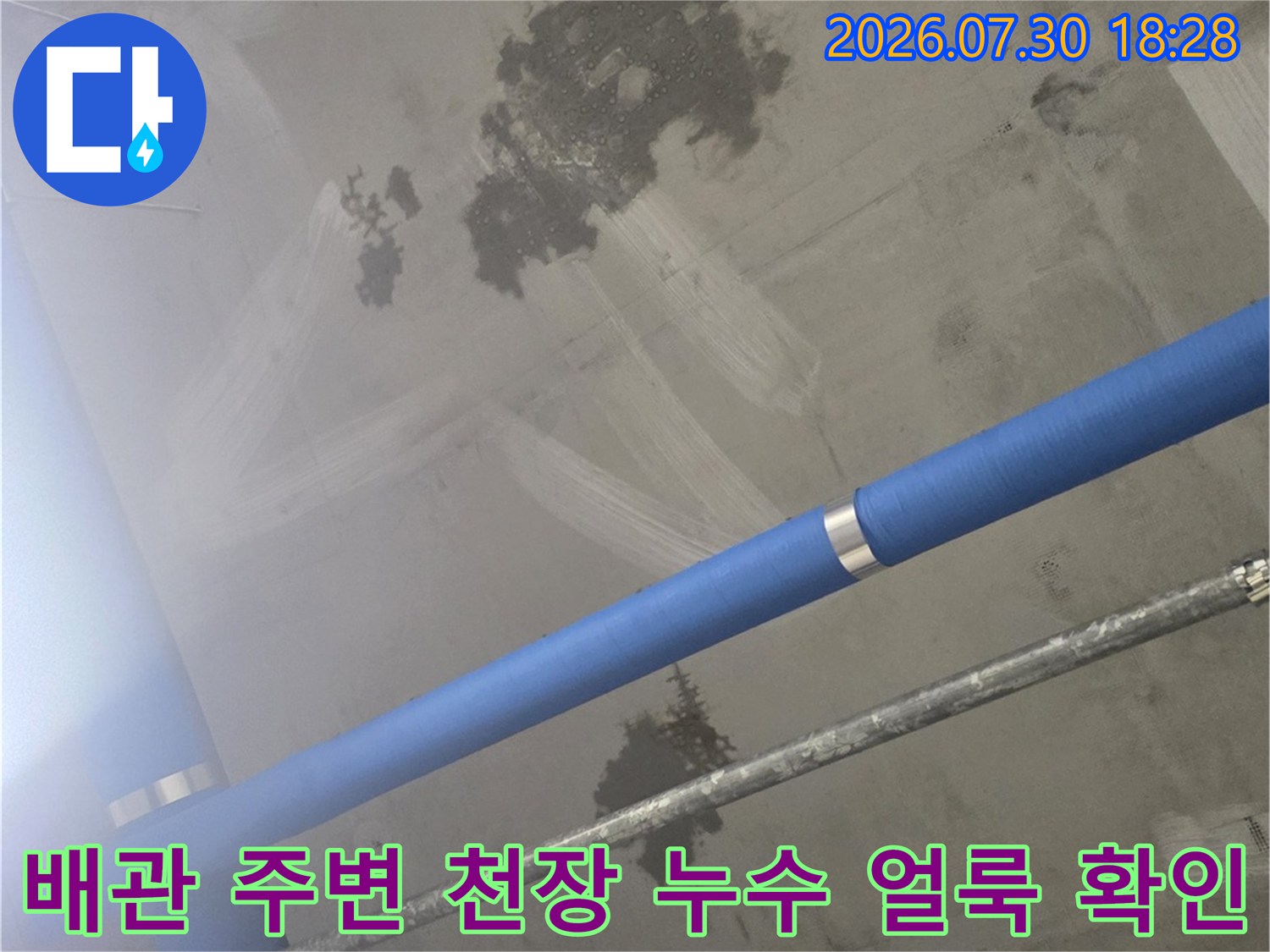 파란색 배관과 천장 콘크리트 표면의 물자국 촬영본