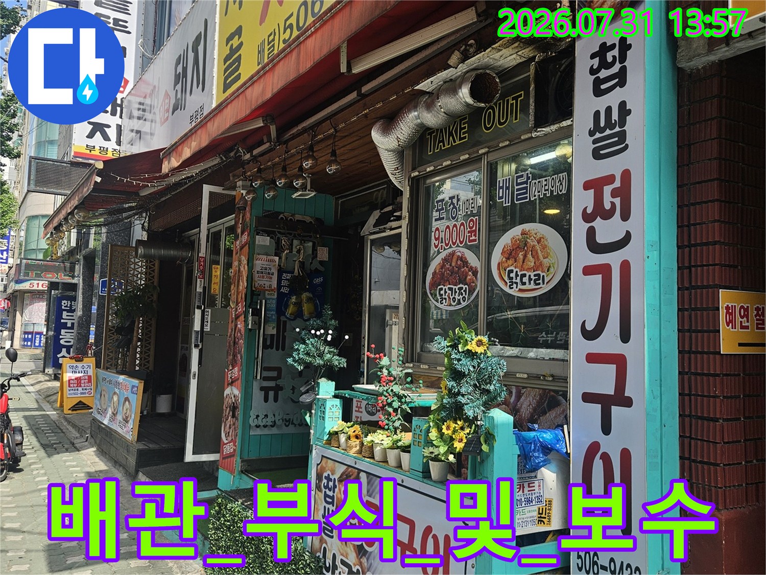 상가 외벽에 노출된 배관과 안내 문구가 적힌 표지판