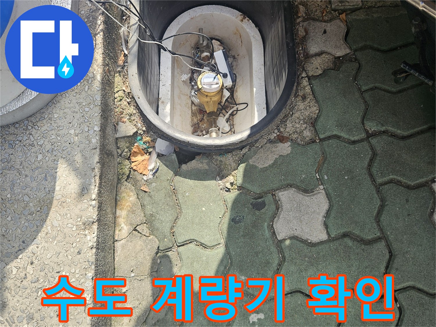 회색 보도블록 옆-수도 계량기 함 내부의 부식된 배관 상태