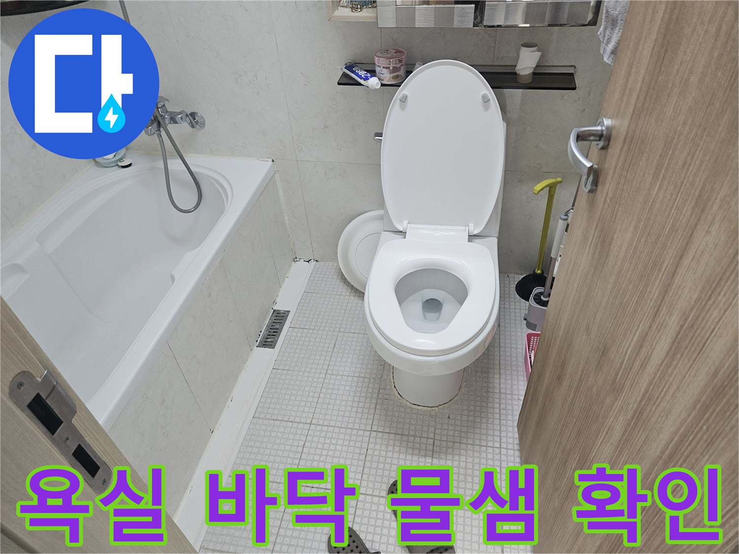 하얀 변기와 샤워기 호스가 보이는 욕실 내부의 수직 부감샷
