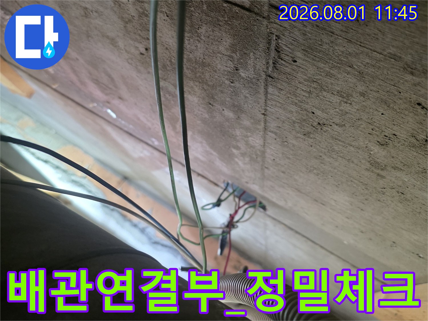 천장 내부의 노출된 배관 연결 부위를 근접 촬영하여 상태를 파악하는 장면
