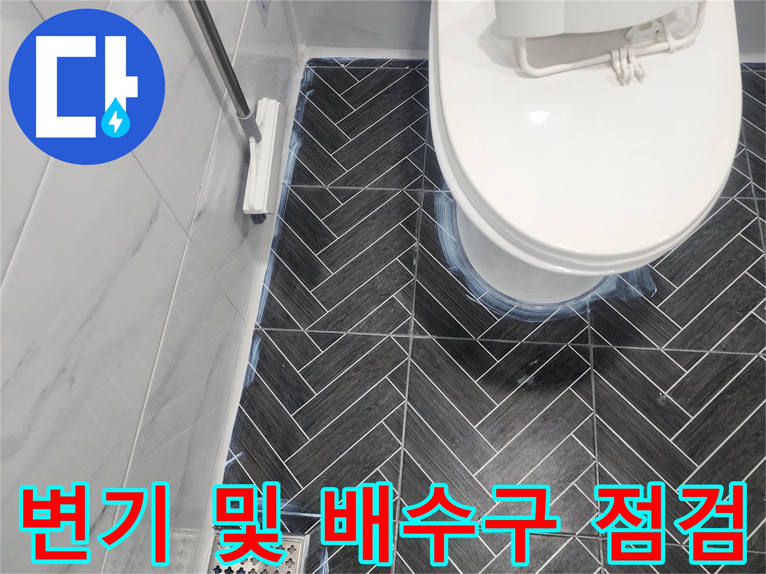 화장실 바닥면-헤링보드 패턴 타일과 배수구 근접 사진